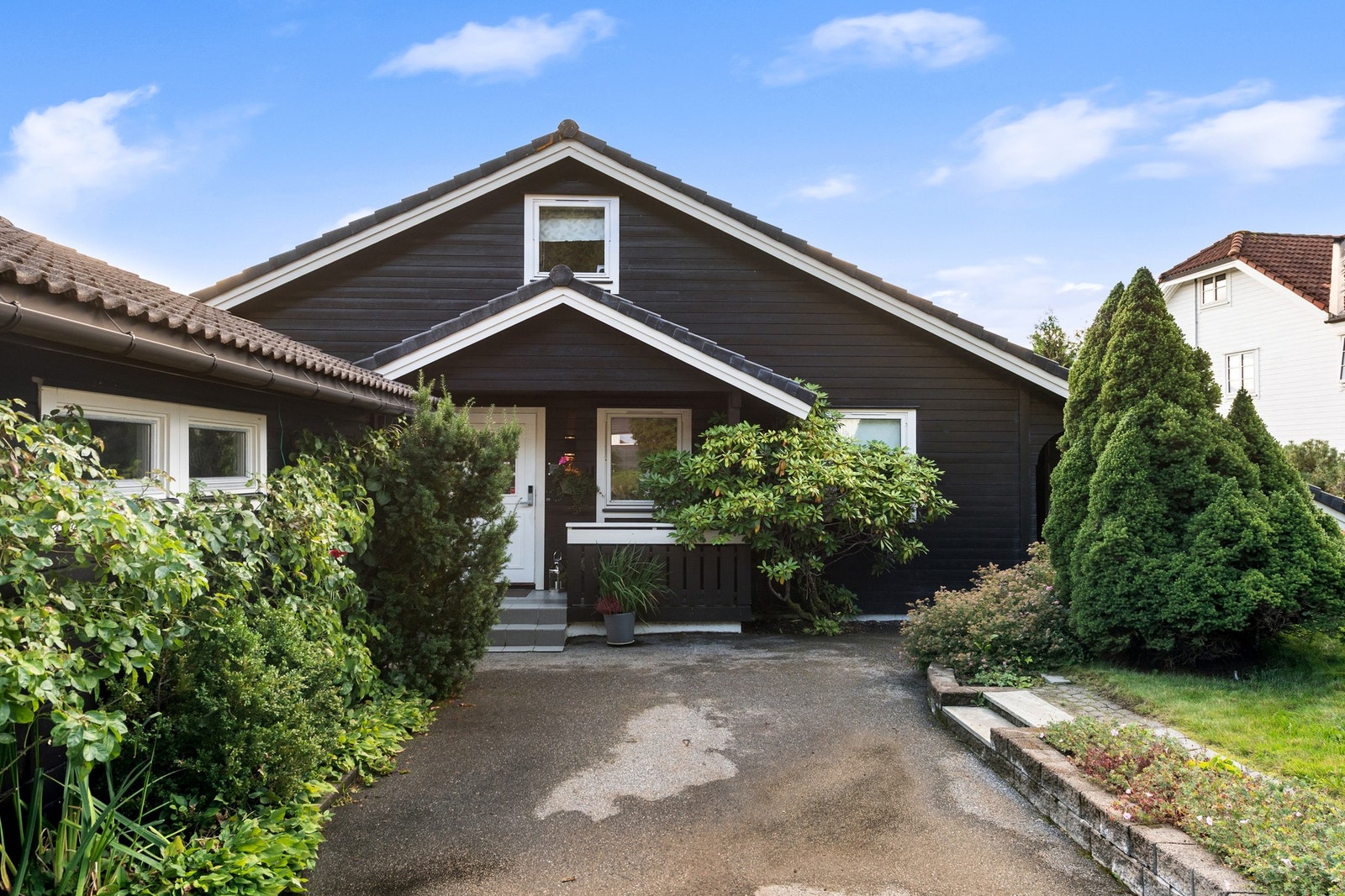 Tomten er pent opparbeidet med plenareal og prydbusker Galleribilde