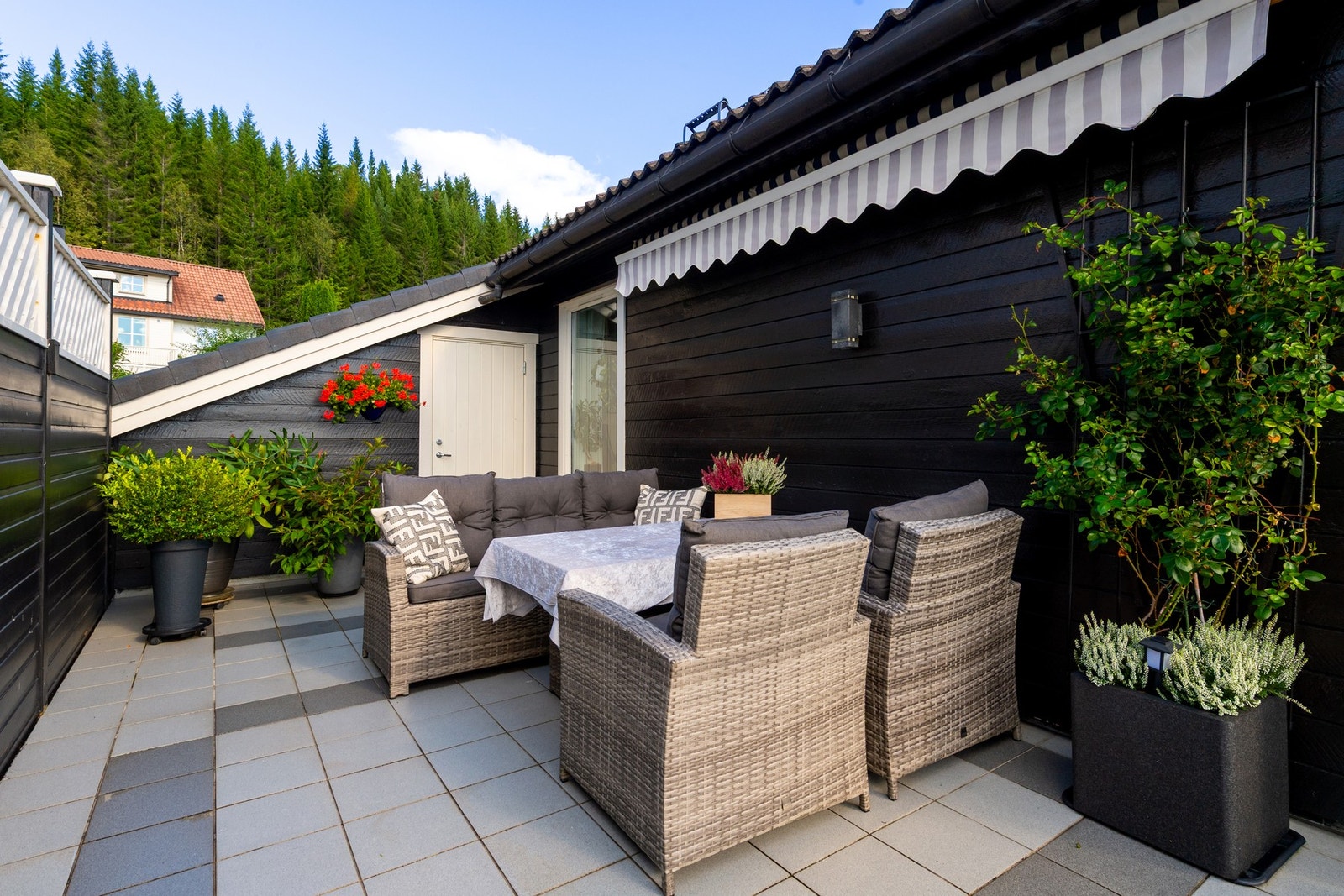 På siden av huset har man en koselig sittekrok. Plassen er skjermet for innsyn Galleribilde