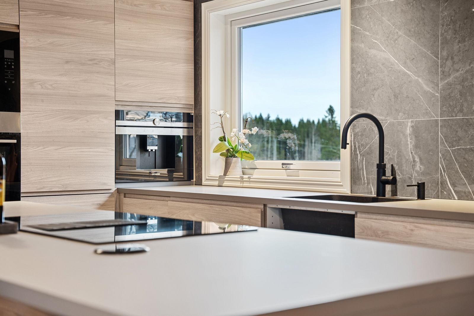 Nedfelt platetopp i kjøkkenøya, med integrert ventilator. Galleribilde