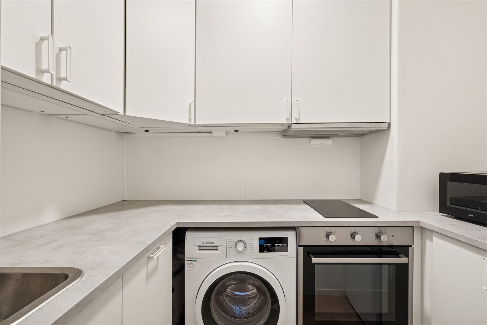 Integrerte hvitevarer som vaskemaskin, oppvaskmaskin, platetopp og stekeovn gir en effektiv kjøkkenløsning. Galleribilde