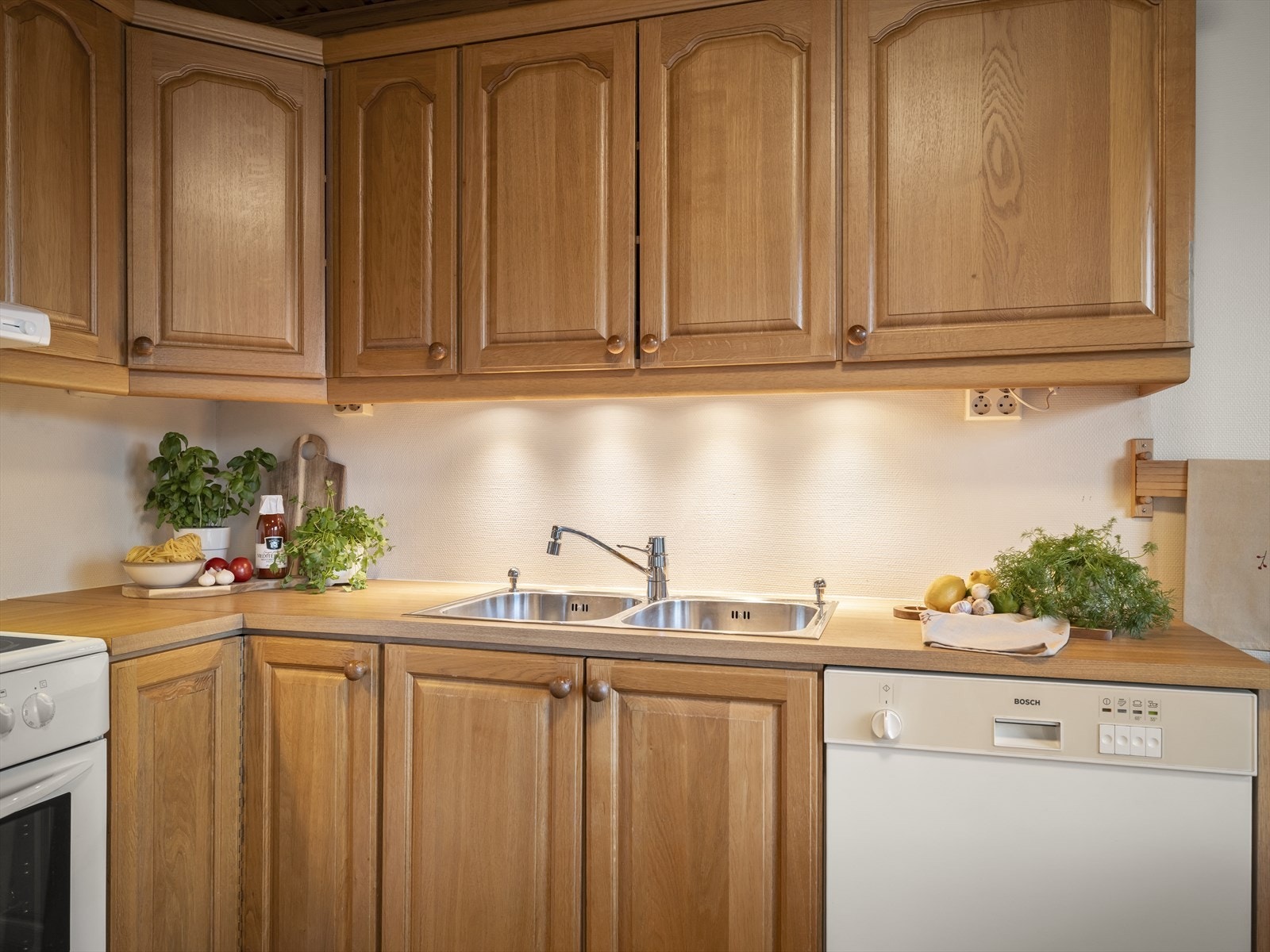 Klassisk kjøkken med profilerte fronter, laminert benkeplate og ventilator med avtrekk ut. Galleribilde