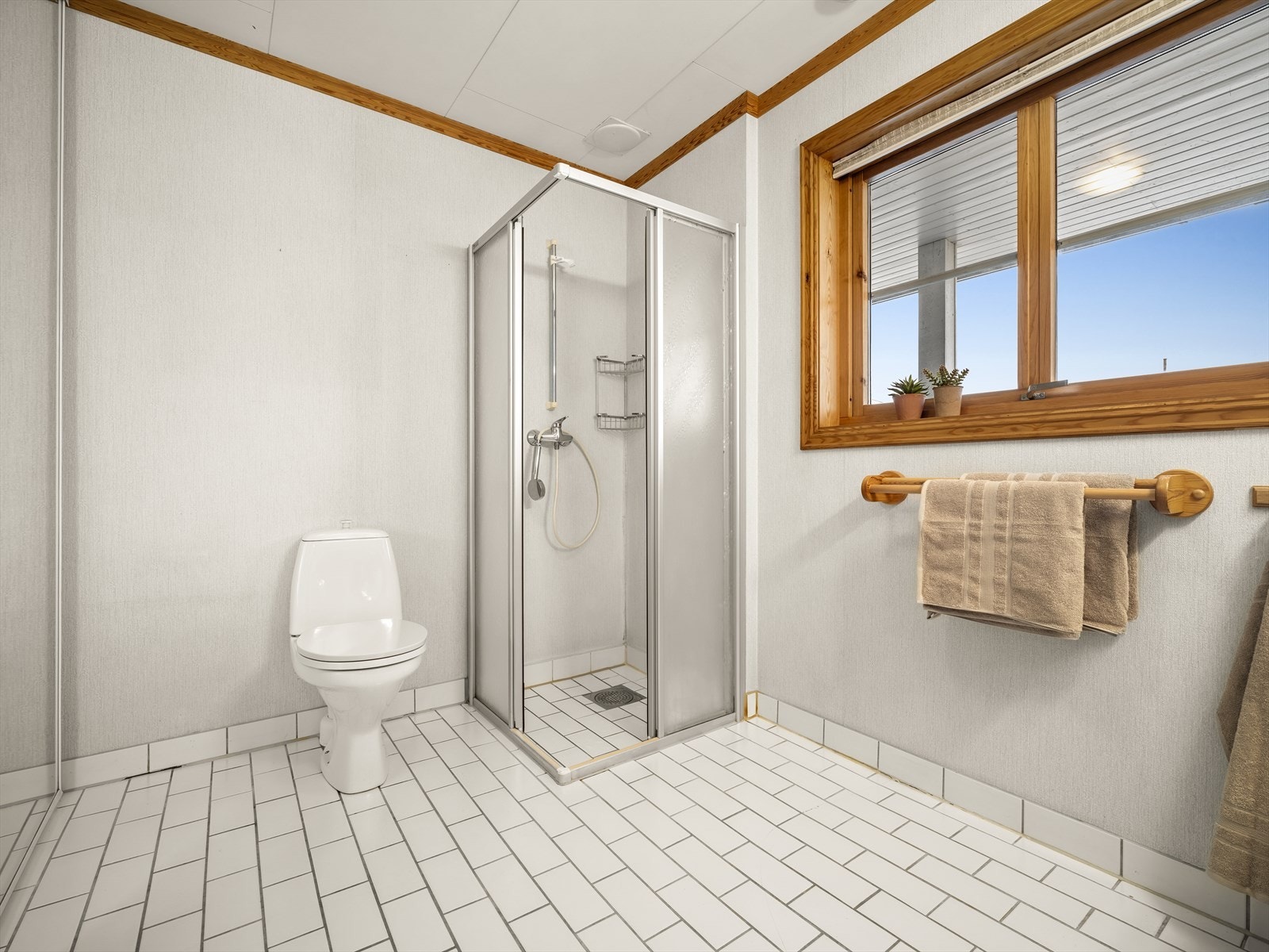 Lyst og pent uttrykk med dusjhjørne i glass og termostatstyrt blandebatteri. Galleribilde