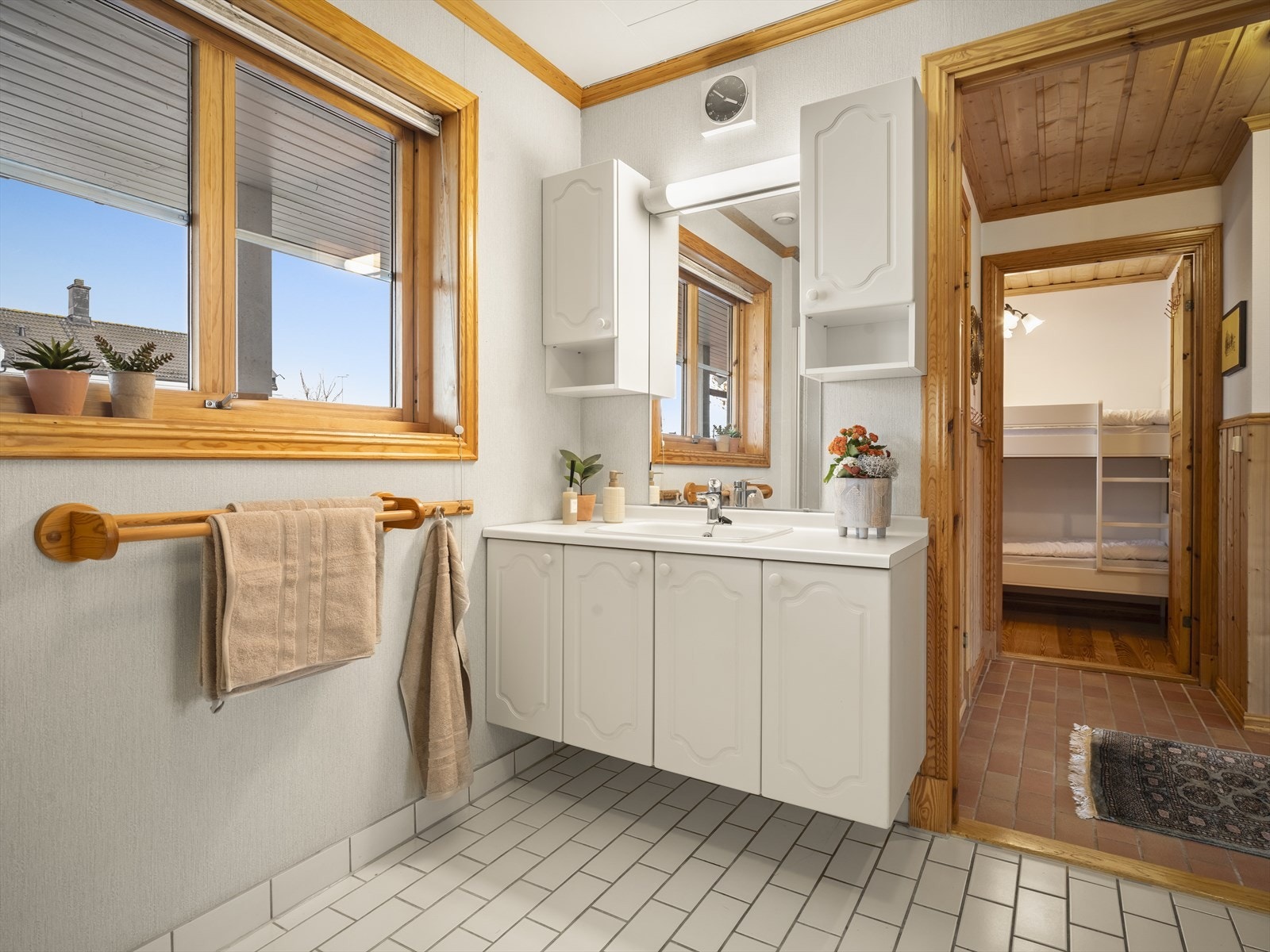 Pent bad med fliser på gulv og praktisk servantinnredning. Galleribilde