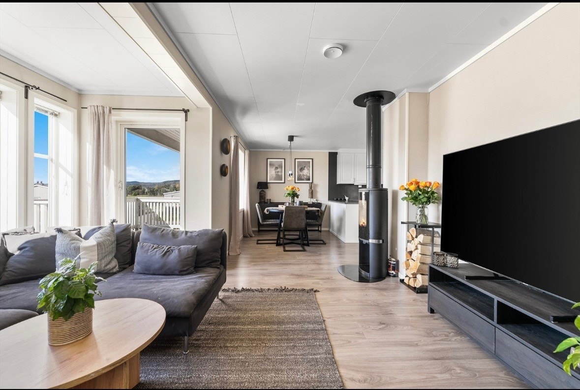 Leiligheten har åpen stue/ kjøkkenløsning som gjør rommet til et hyggelig og sosialt oppholdsrom Galleribilde