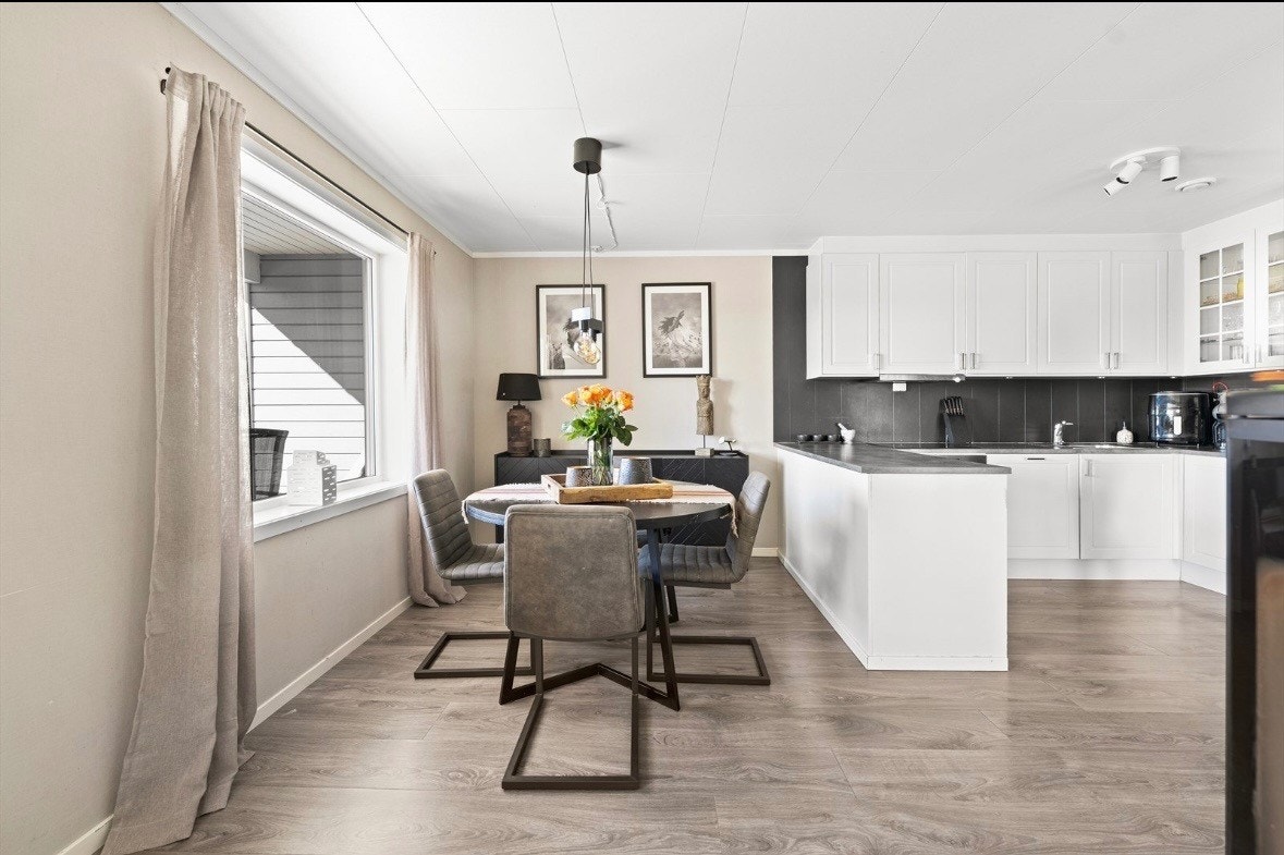 Pent kjøkken med god skap og benkeplass, innredningen består av profilerte fronter laminert benkeplate. Flis over benkeplater belysning og kjøkkenkum. Galleribilde