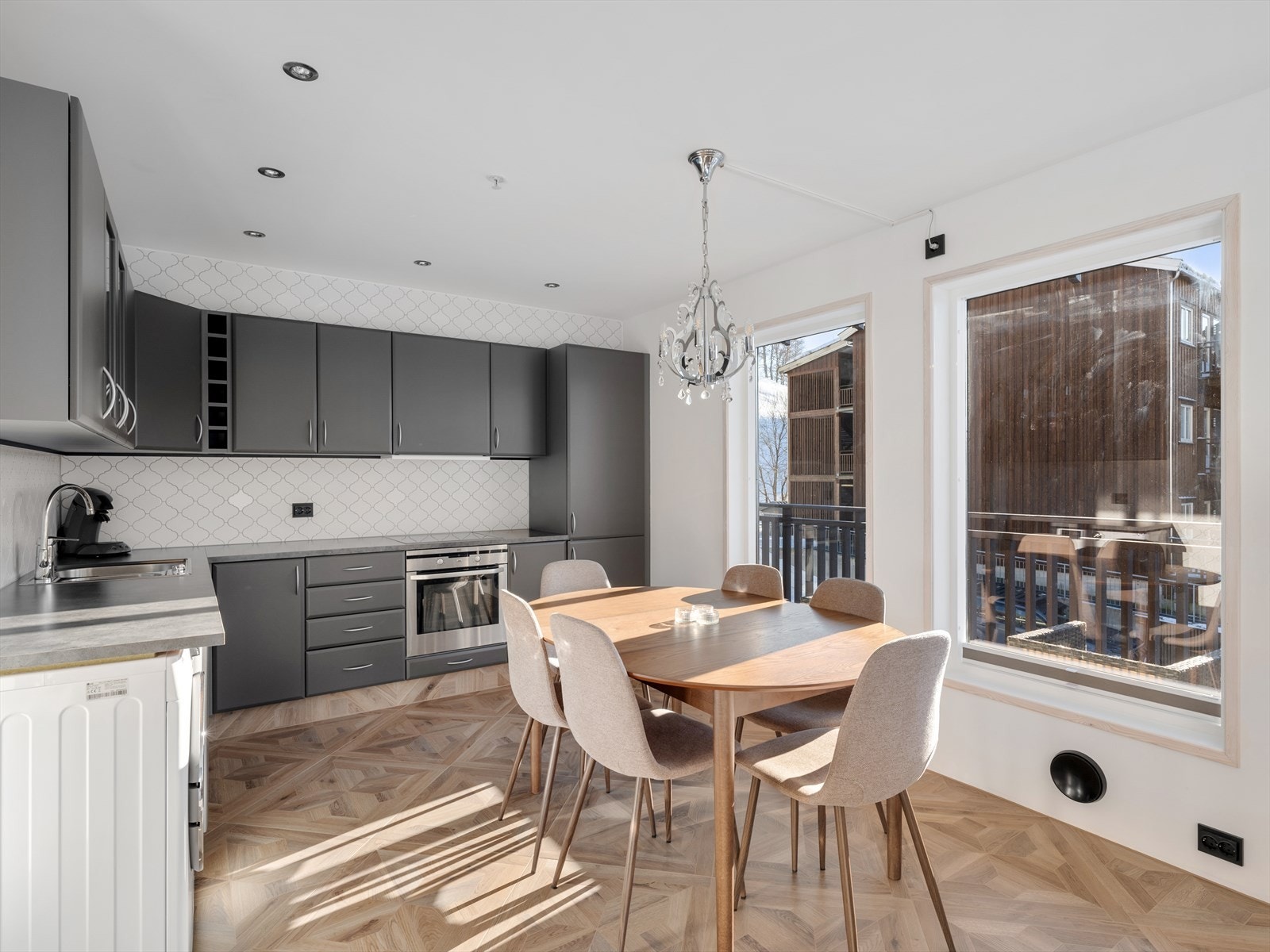 Delikat kjøkken i tidløs grå. Spotter i tak og sorte elco+ brytere gir fine detaljer. God arbeidsbenk og plass til langbord med gjester. Galleribilde