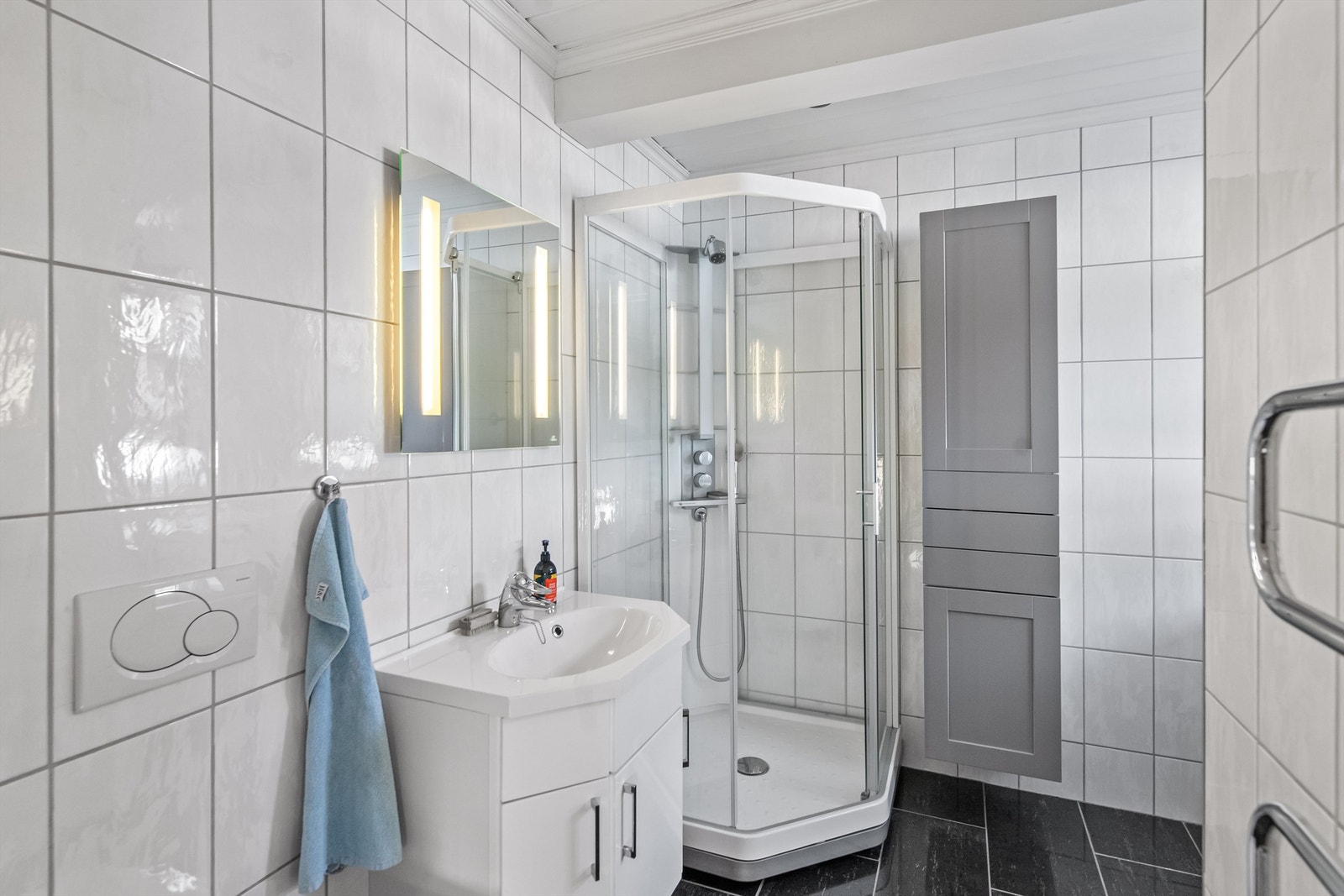 Tidløst flislagt bad med varmekabler i gulv og downlights i tak Galleribilde