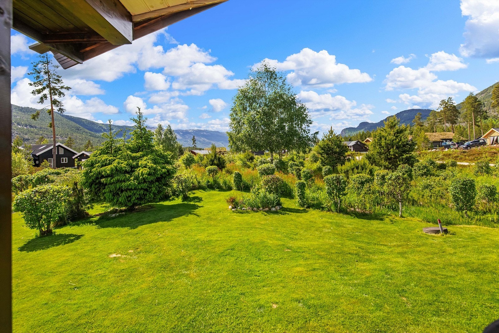Utearealene er pent opparbeidet. Det er plensatt med prydbusker og bed og med en robotklipper som holder hagen pen Galleribilde
