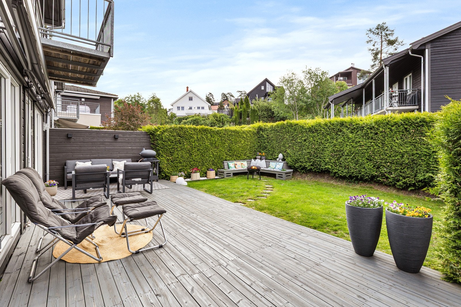 Terrassen og hagen er skjermet med tjuahekk som gir en privat ramme rundt uteplassen. Galleribilde