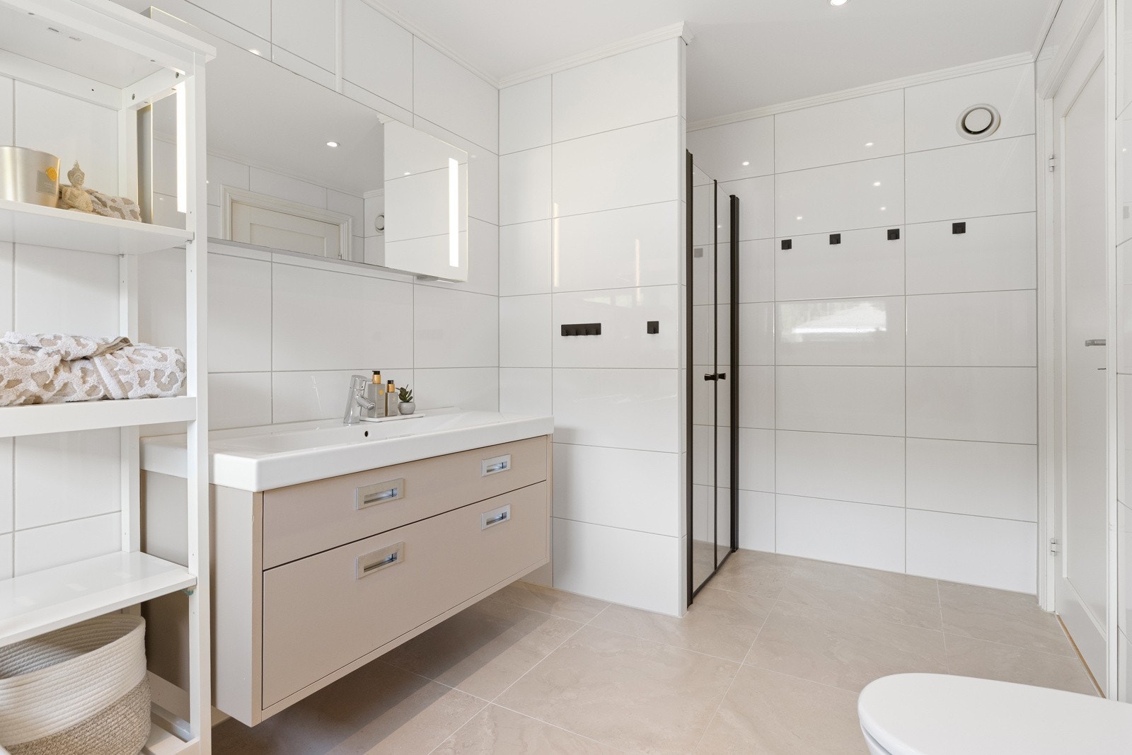 Badet har flislagte vegger og gulv, varmekabler og innfelt downlights. Galleribilde