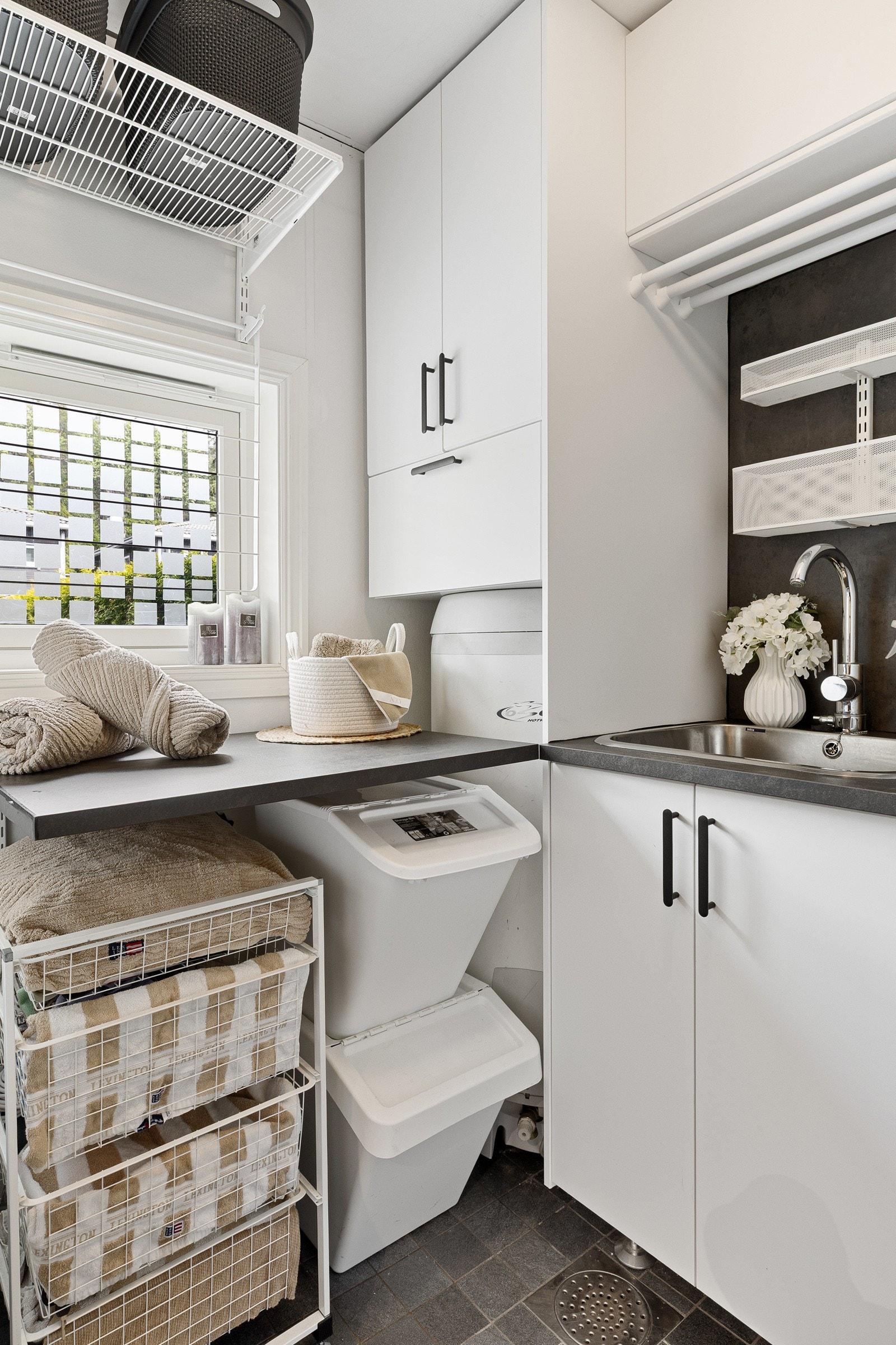 Rommet er innredet med flere skap/innredninger, laminert benkeplate med nedfelt oppvaskkum og opplegg for vaskemaskin. Galleribilde