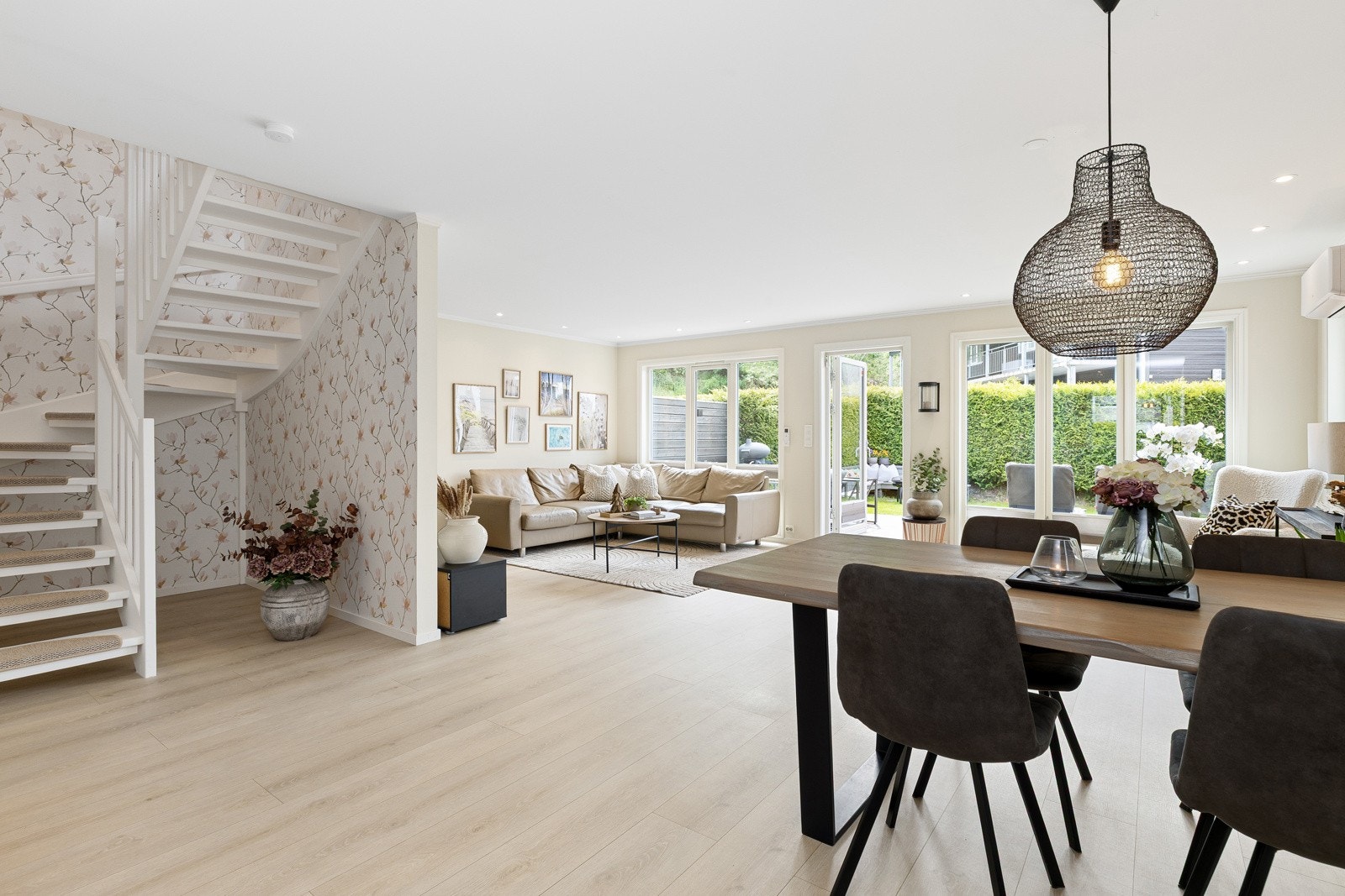 Stuen har et lyst og luftig design der store vindusflater slipper inn rikelig med naturlig lys og skaper en åpen, innbydende atmosfære. Galleribilde