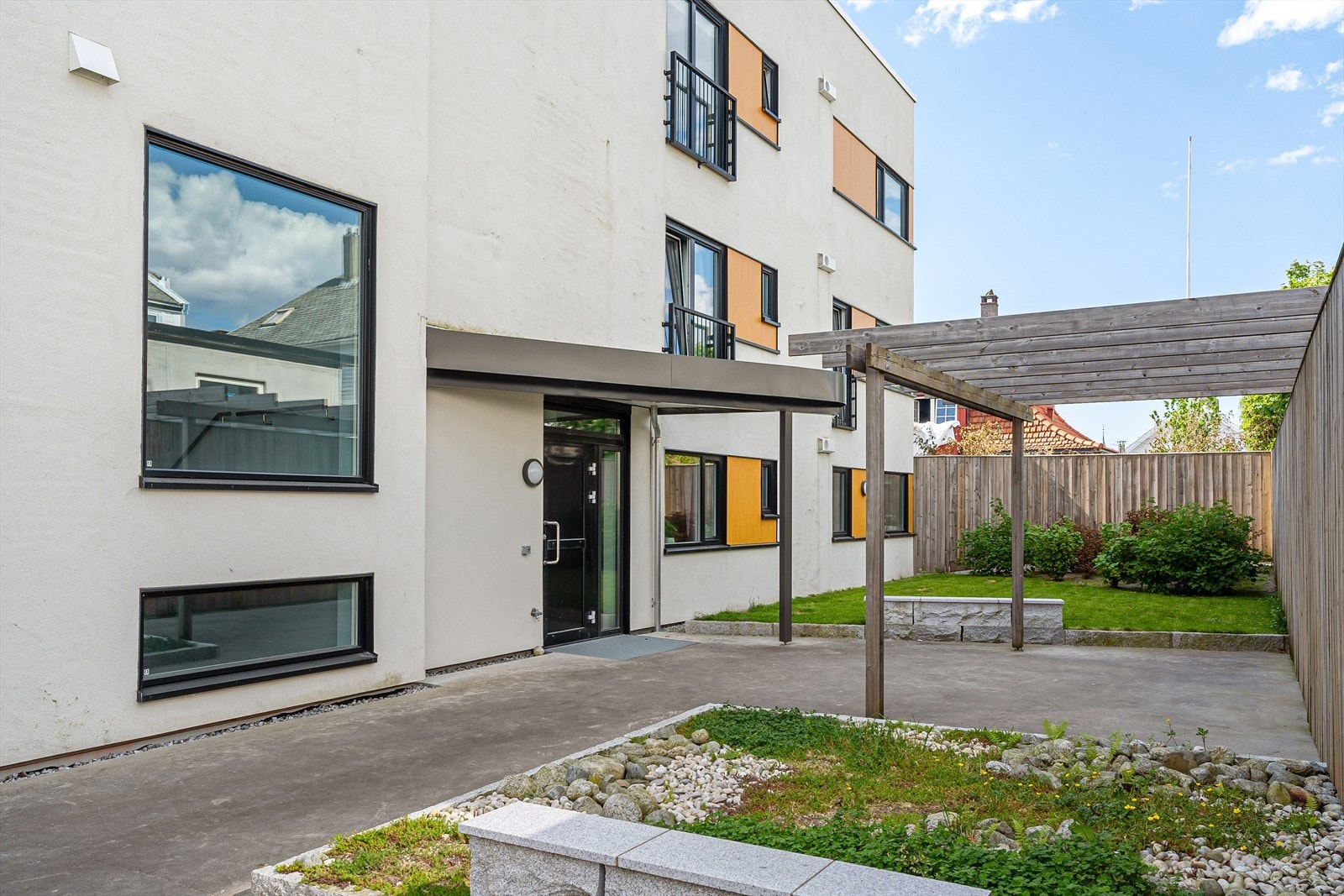 Flott bakgård med inngangsparti, pergola og beplantning. Galleribilde