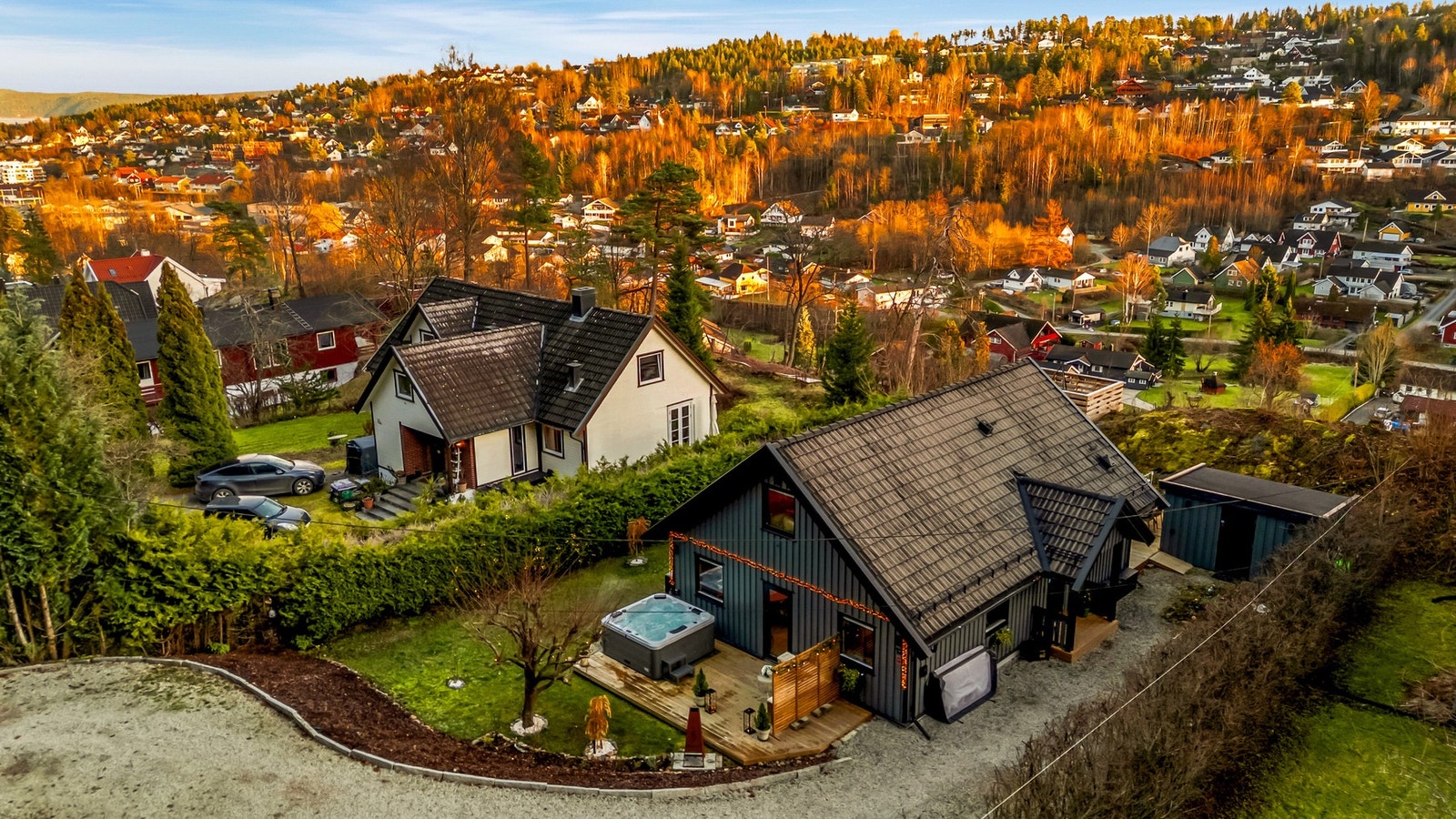Bilen parkeres i en singlet innkjørsel med lader for elbil montert på husveggen. Galleribilde