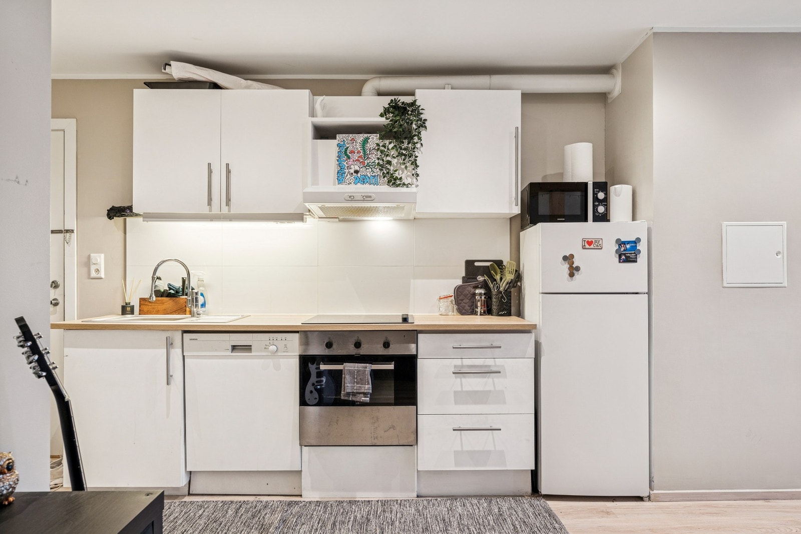 Et pent kjøkken med integrert stekeovn og oppvaskmaskin. Galleribilde