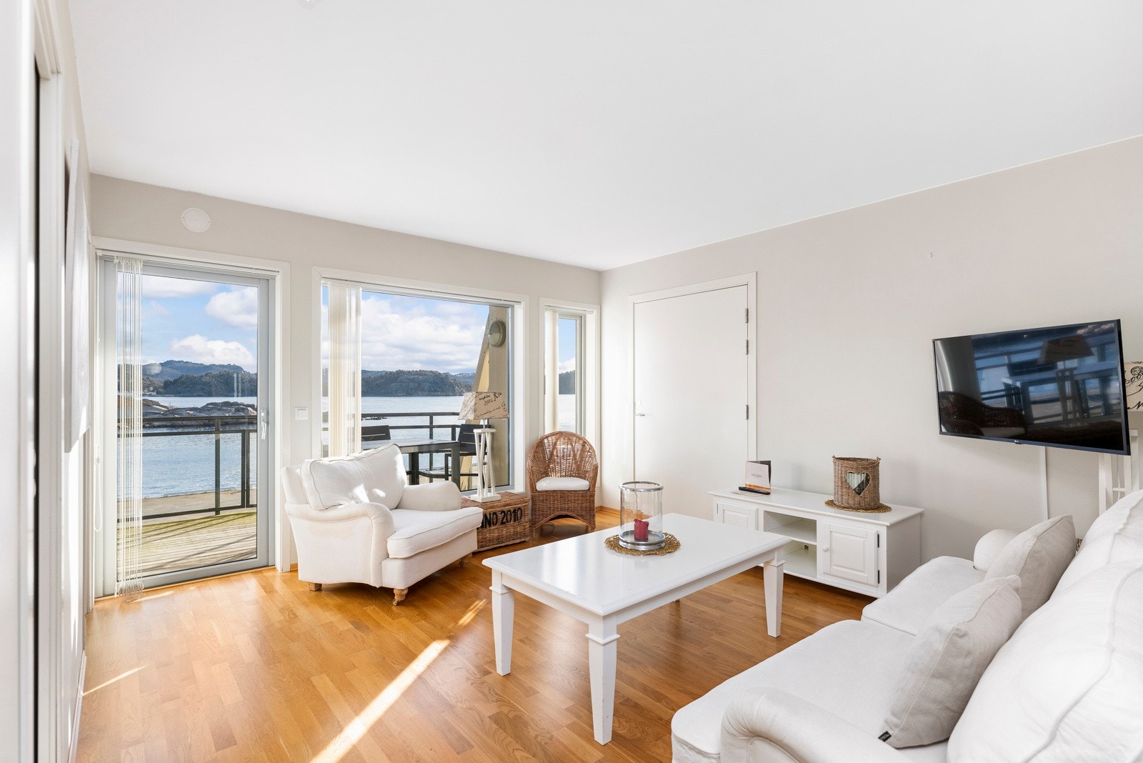 I stua er store vindusflater som gir godt med lys inn i leiligheten, her er også utgang til veranda samt dør til tilknyttet hotellrom Galleribilde