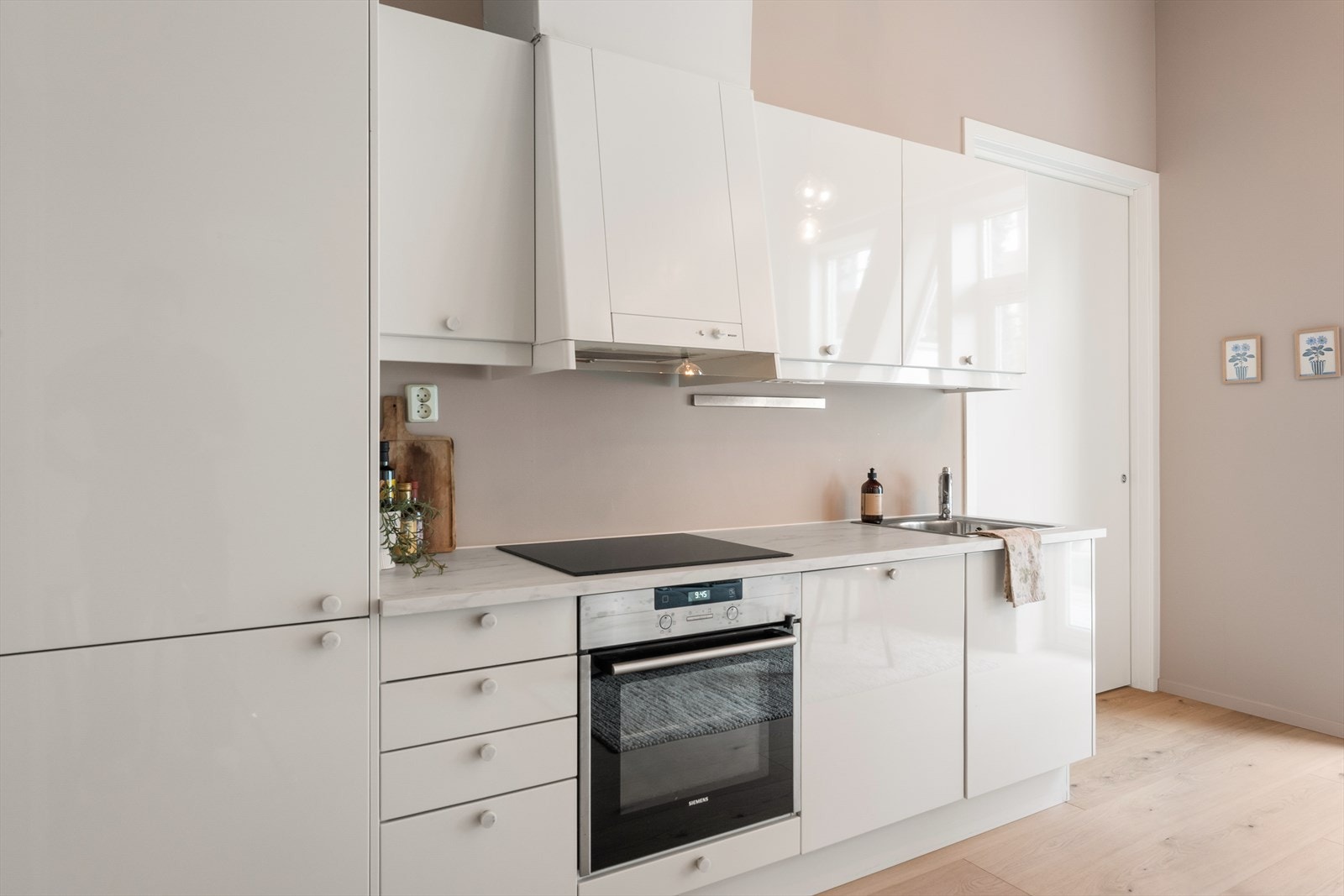 Kjøkkenet har en flott innredning med hvite fronter, ny benkeplate og integrerte hvitevarer. Flott marmordesign på både benkeplate og knotter. Galleribilde