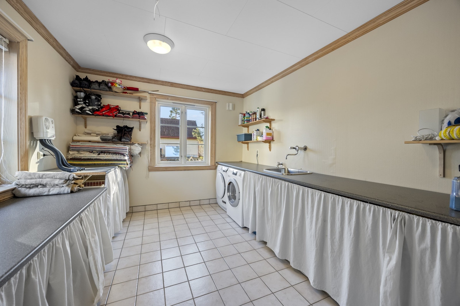 Vaskerom med benker og gode løsninger. Det er varmekabler i gulv i rom med fliser. Galleribilde