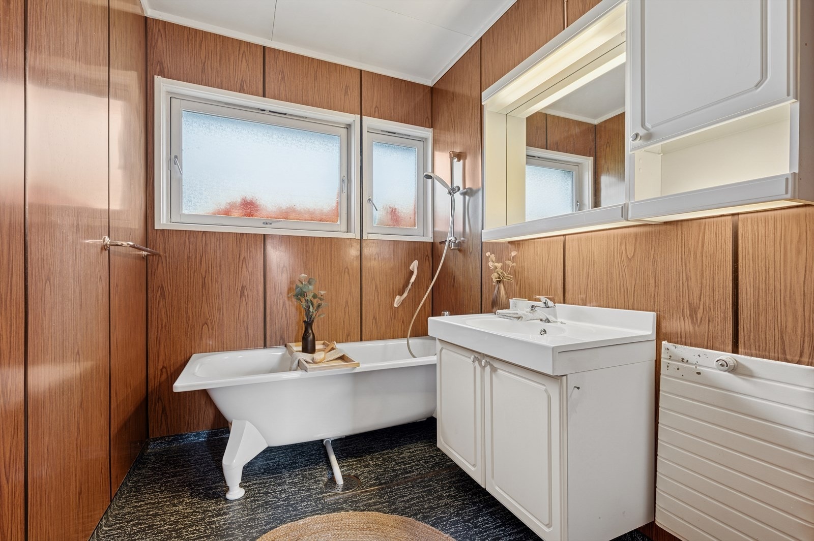 Eldre bad utstyrt med badekar og lys baderomsinnredning. Galleribilde