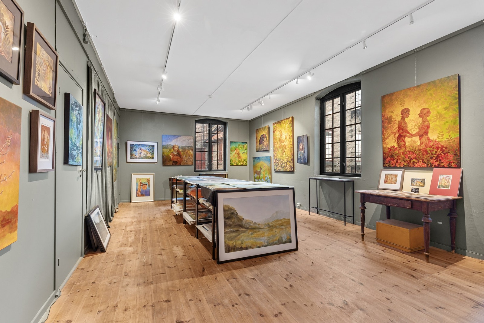 Lyst atelier med furugulv og malte murvegger. Lysskinner i himling gir fleksibel og presis belysning Galleribilde