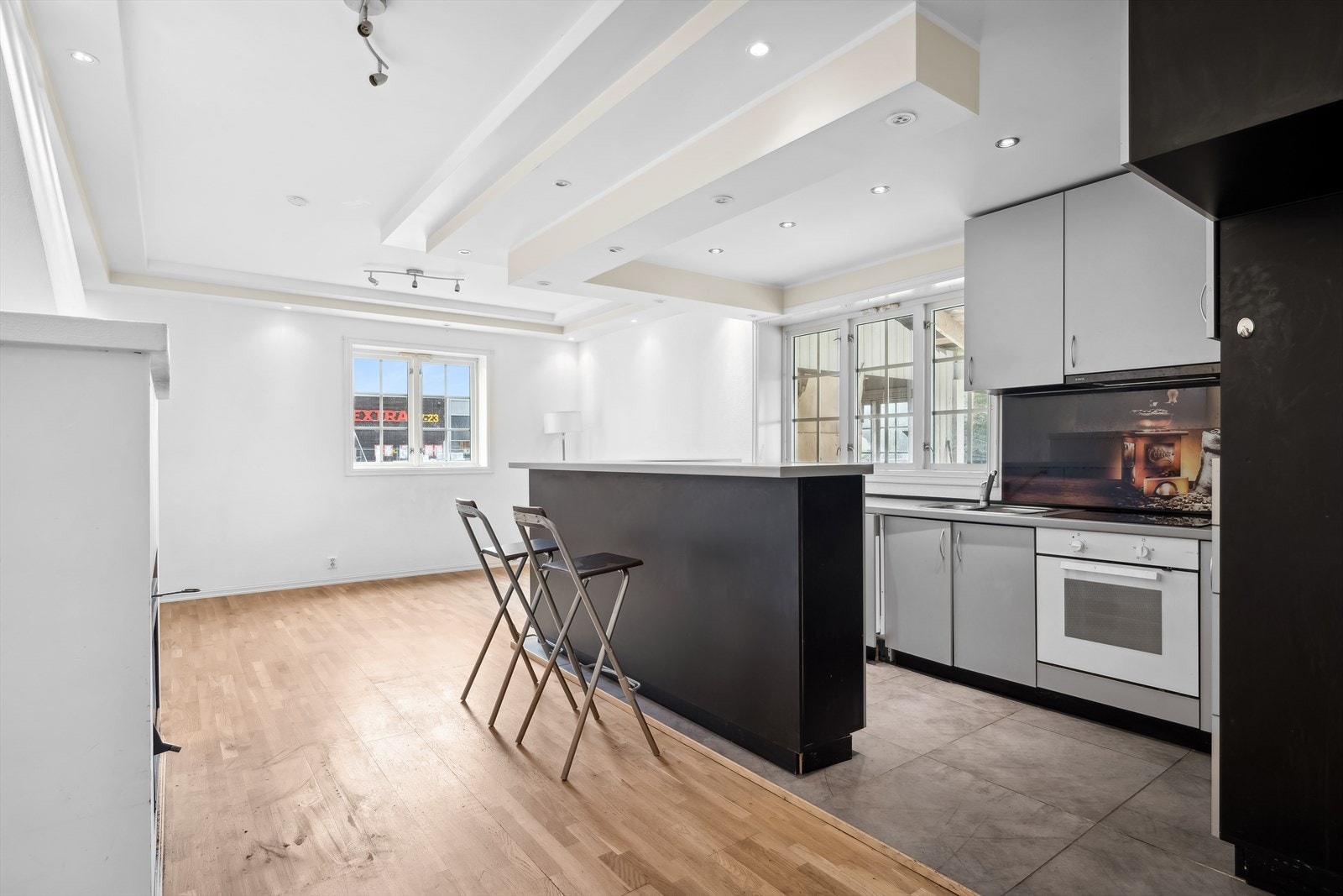 Stilrent stort kjøkken med integrert stekeovn, platetopp og oppvaskmaskin. Det er plass for spisebord i rommet Galleribilde