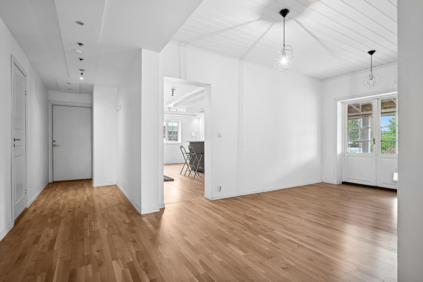 VI starter i første etasje og tar oss fra gangen og videre inn i en lys stue Galleribilde