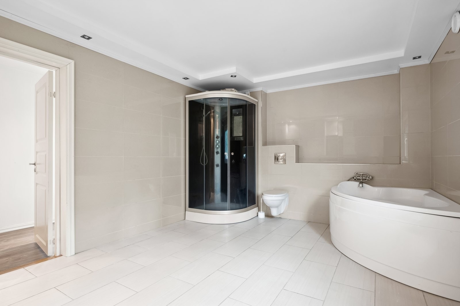 Innredet med badekar, dusjkabinett, vegghengt wc og lys baderomsinnredning Galleribilde