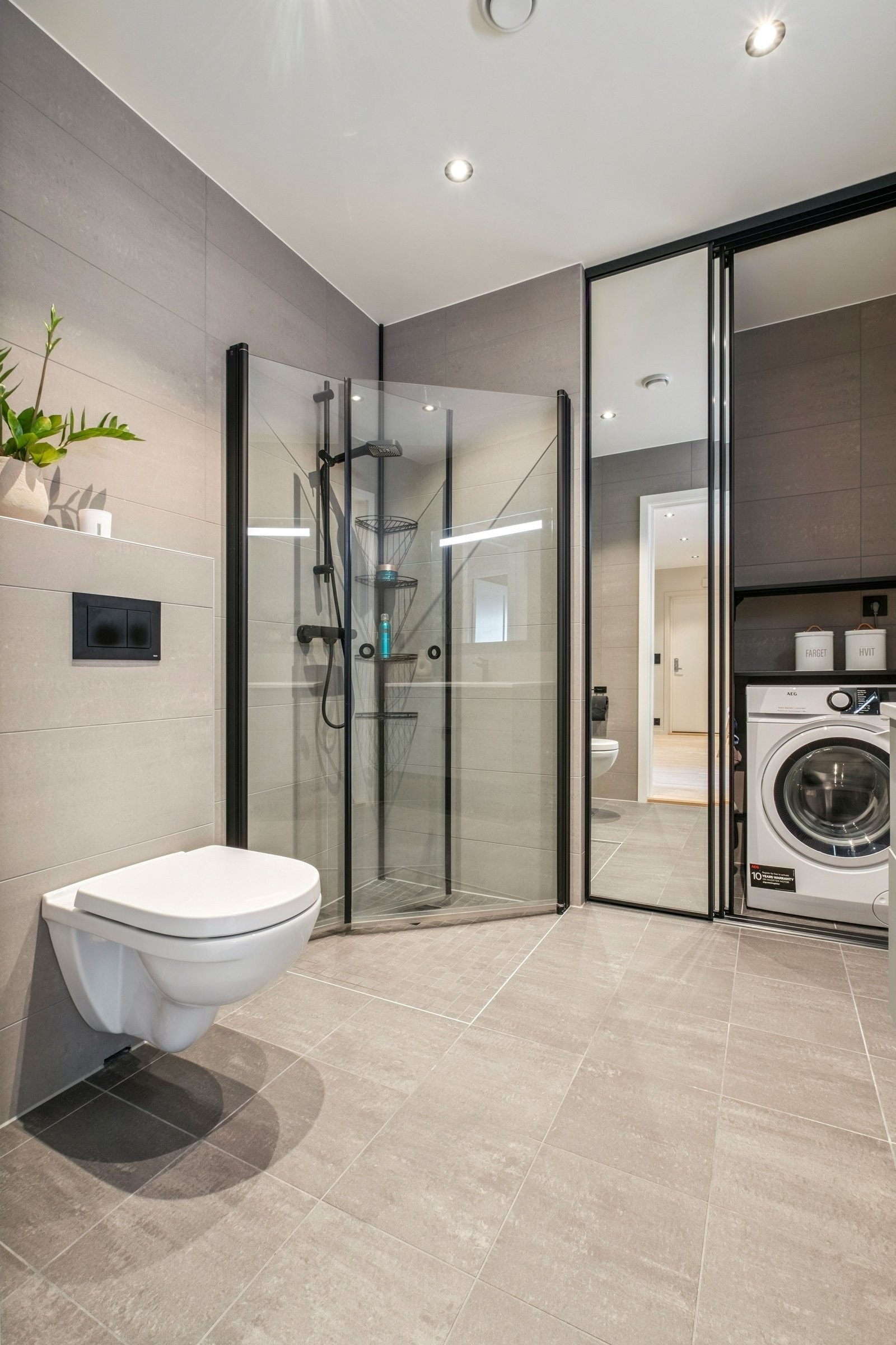 Betydelig påkostet bad med mørke fliser og sorte detaljer. Galleribilde