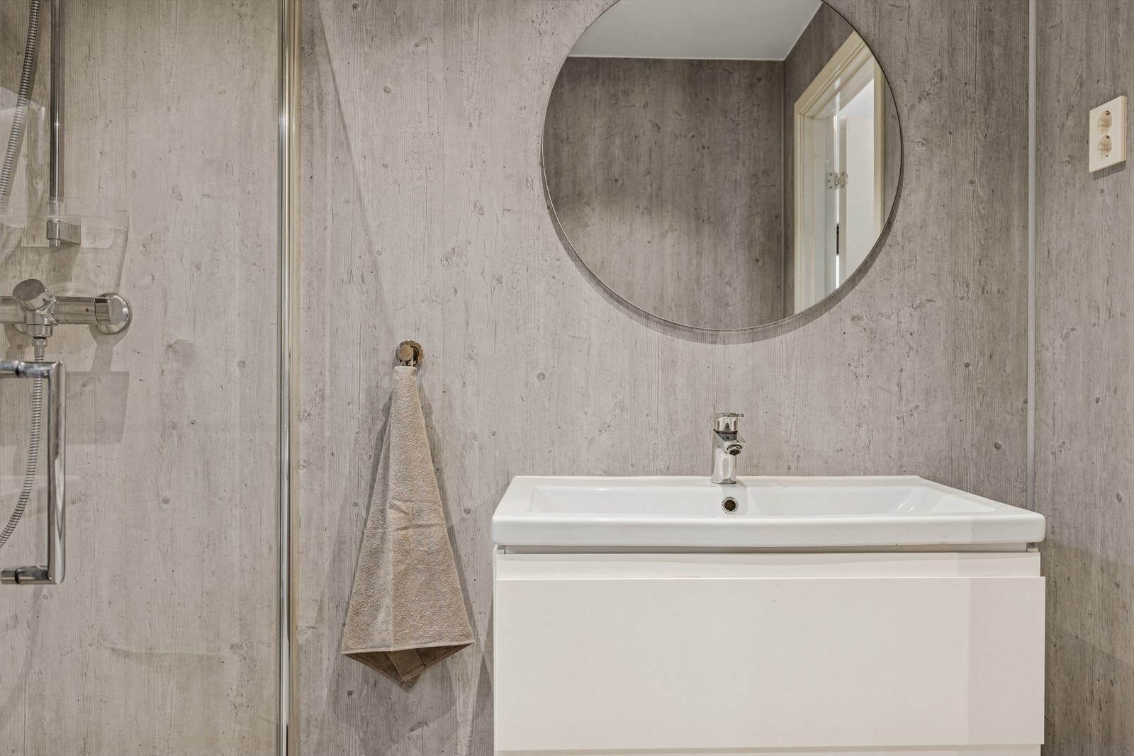 Rommet fremstår som en romslig velværeavdeling som byr på dusjhjørne, seksjon med heldekkende vask og veggmontert toalett. Galleribilde