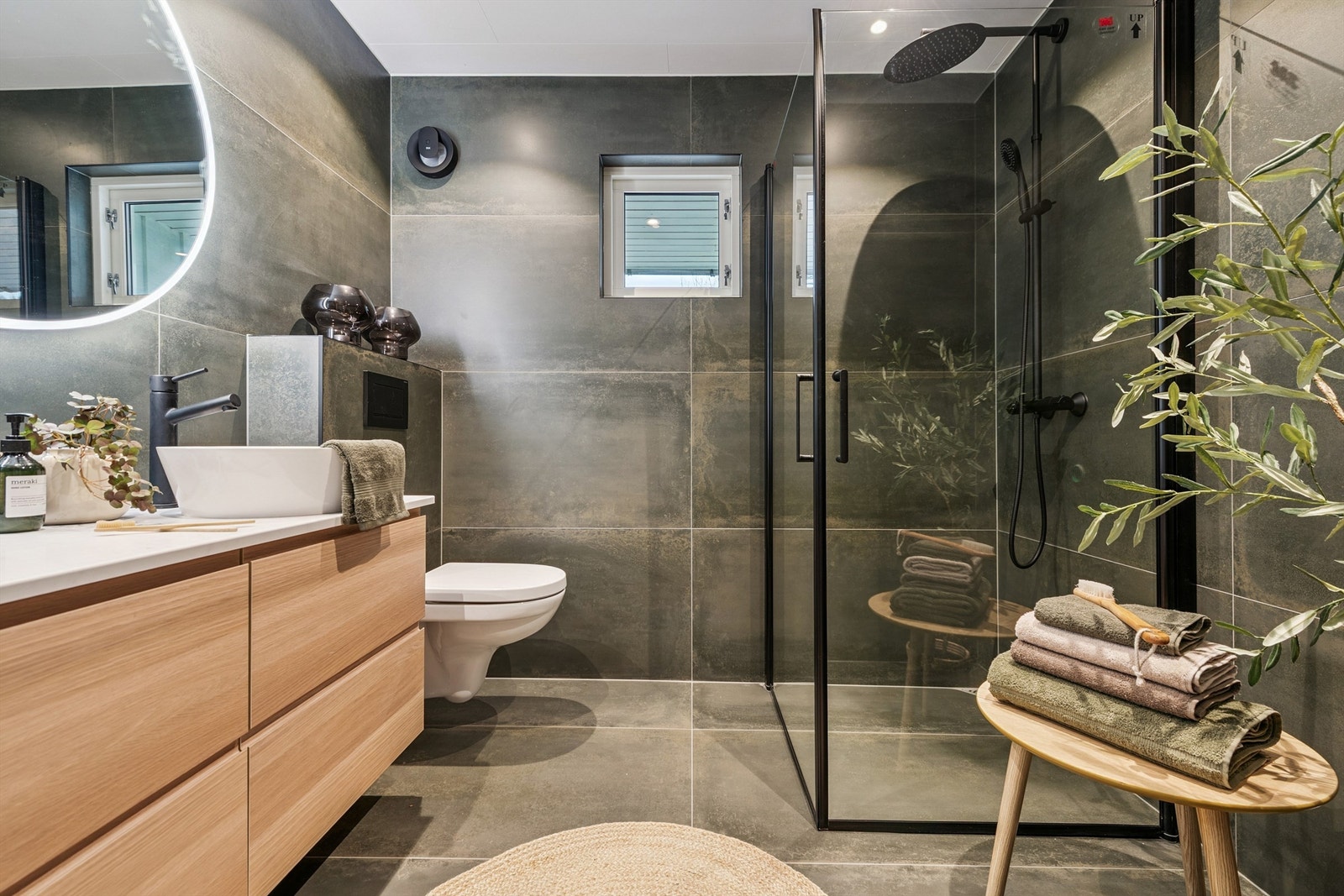 Her er det lune moderne fliser, regnfallsdusj og dusjdører med delikate sorte detaljer. Galleribilde