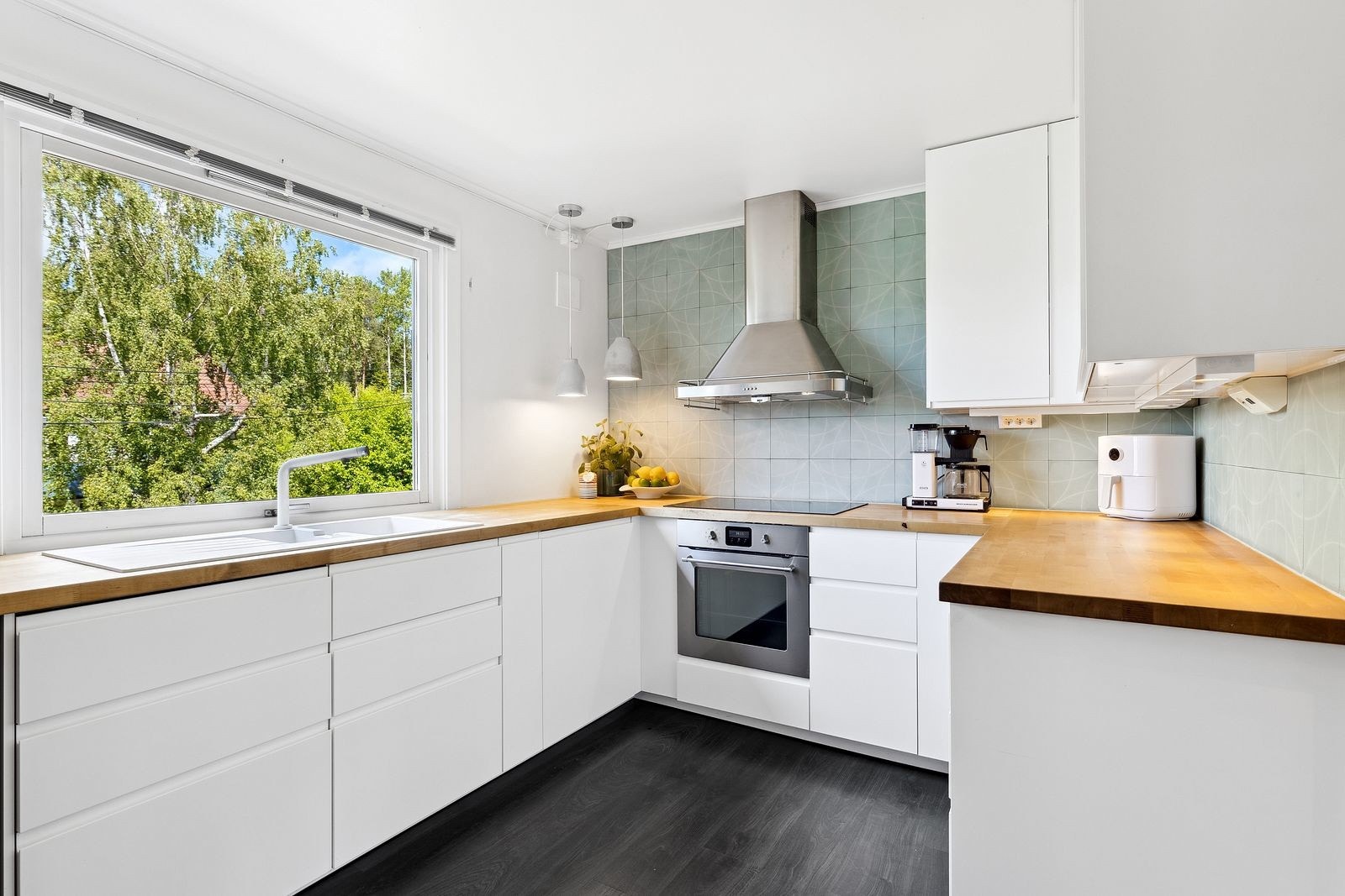 Kjøkkeninnredning fra 2017 med glatte fronter og laminat benkeplate Galleribilde