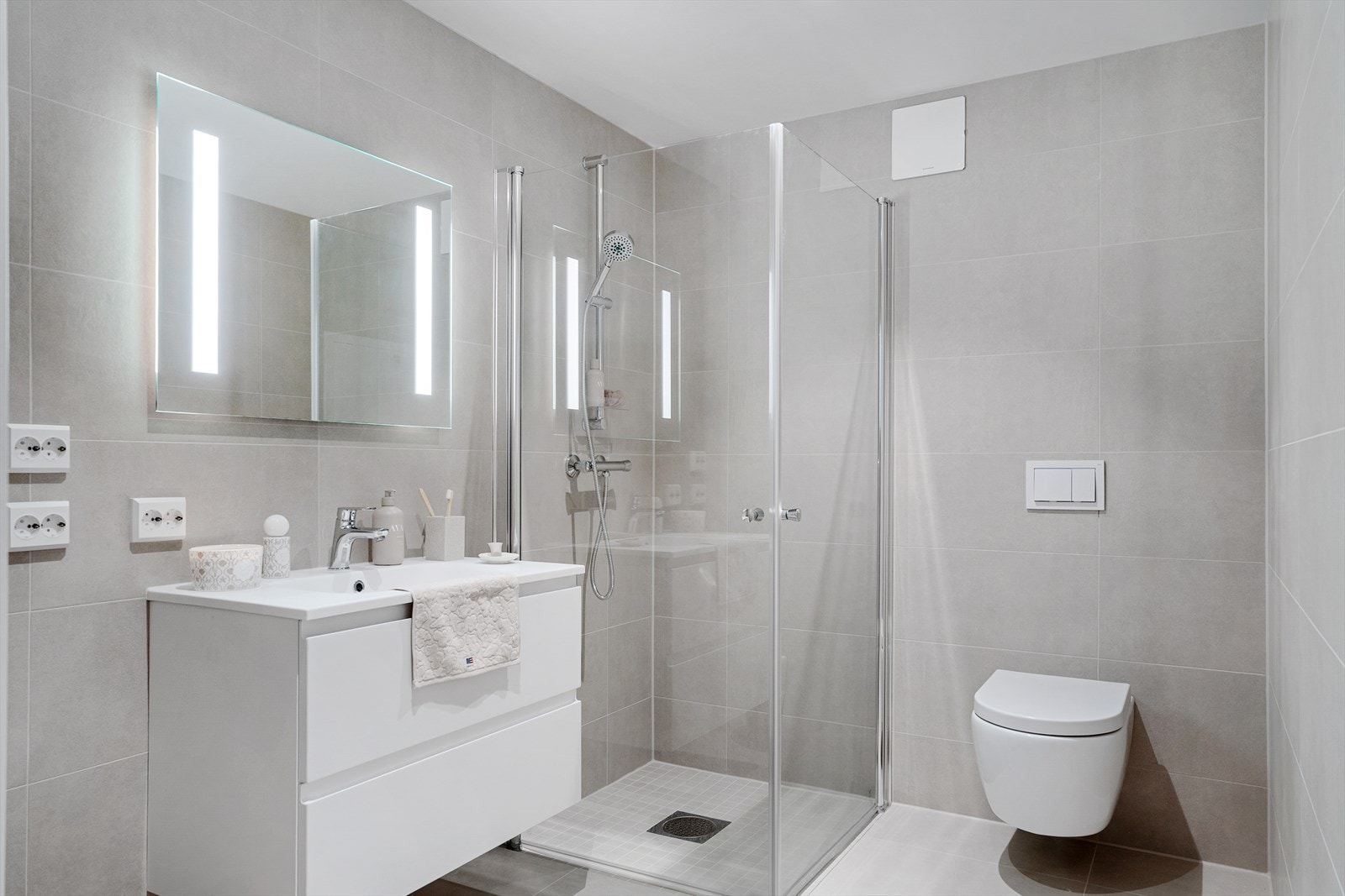 Lekkert og helfliset bad med varmekabler. Fliser i nydelige gråtoner. Galleribilde