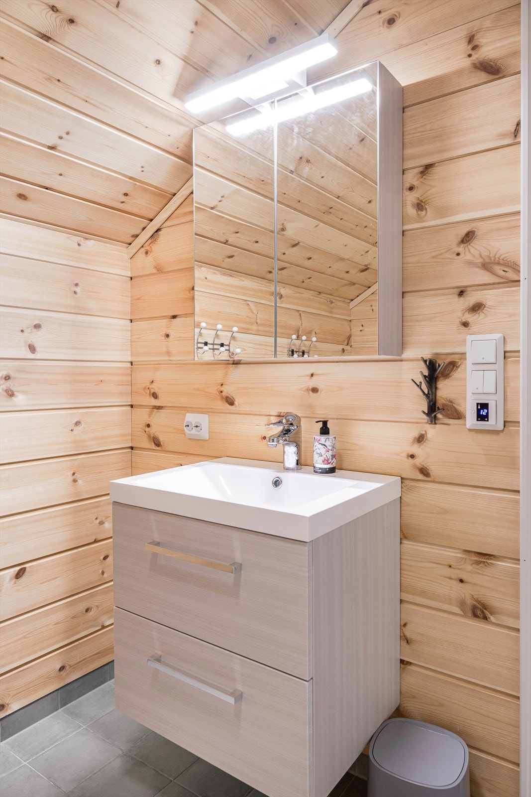 Speilskap i tillegg til seksjon for god oppbevaring. Stikkontakt ved vasken for barbermaskin eller tannkost. Varme i flislagt gulv. Galleribilde