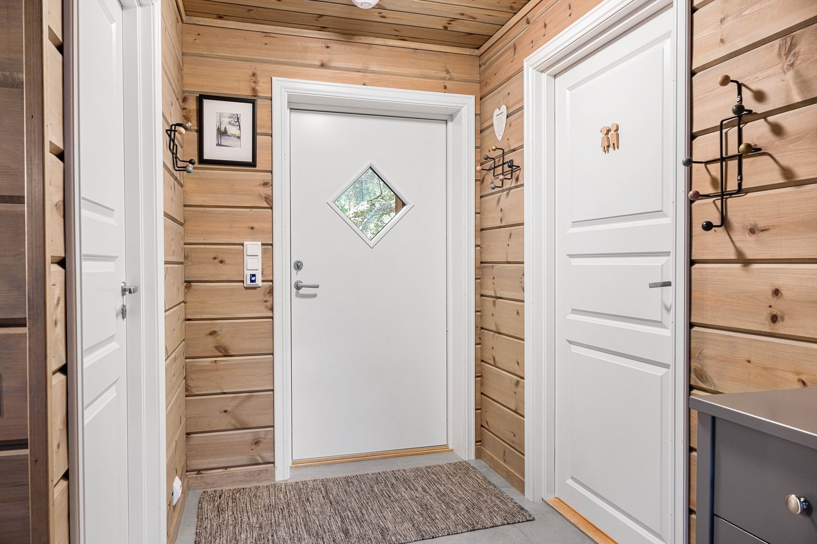 Entre med varme i gulv og fliser som tåler litt fuktige skisko. Plass for oppheng og ekstra kommode for oppbevaring. Galleribilde