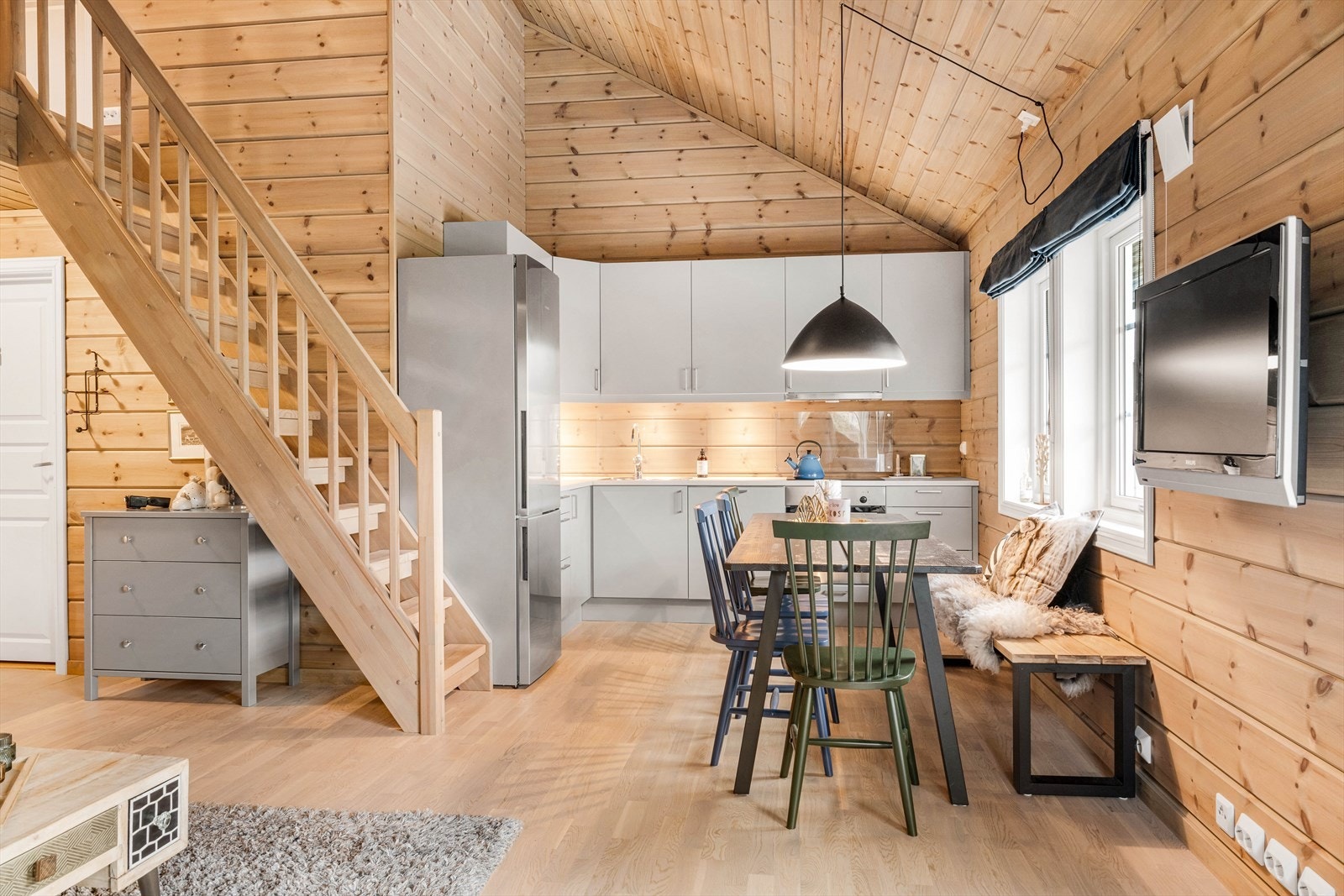 Smart plassering på kjøkkenet frigjør plass for møblering, og optimaliserer romfølelsen. Sammen med ekstra god takhøyde, østerdalspanel og mye naturlig lys - får du en herlig hytteatmosfære. Galleribilde