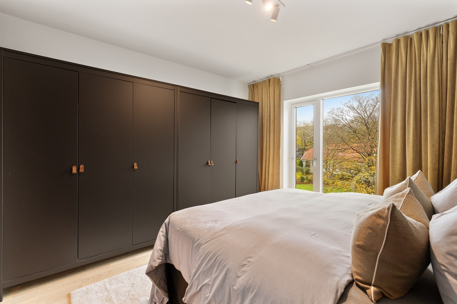 Hovedsoverom med stor garderobe og store vinduer som gir flott utsikt til grønne omgivelser. Harmonisk og innbydende atmosfære. Tenk å starte dagen din her! Galleribilde