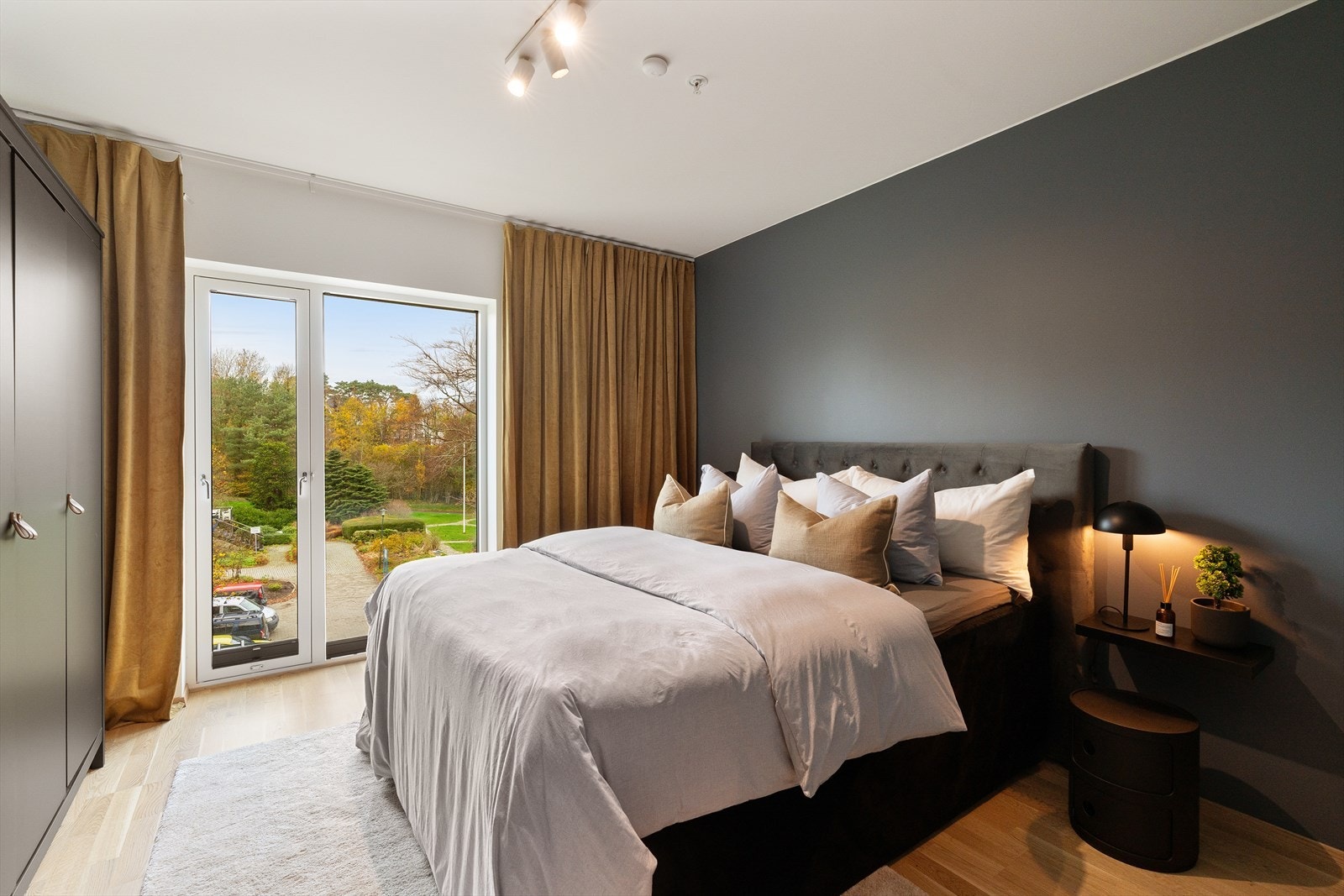 Lyst og romslig soverom med store vinduer som slipper inn naturlig lys, og utsikt mot vakre uteområder. Galleribilde