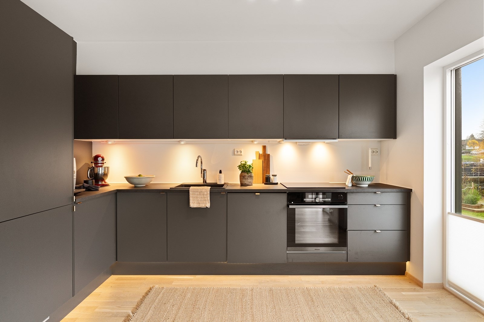 Moderne kjøkken fra Norema med rene linjer og stilfull design, perfekt for matlaging og sosiale sammenkomster. Godt lysinnslipp gjennom store vinduer. Galleribilde