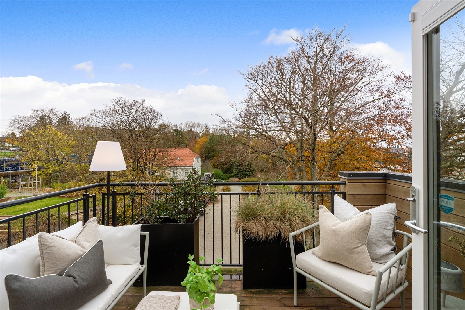 Nyt frodige, grønne omgivelser fra en romslig balkong med utsikt over nabolaget. Perfekt for avslapning og utendørs hygge. Galleribilde