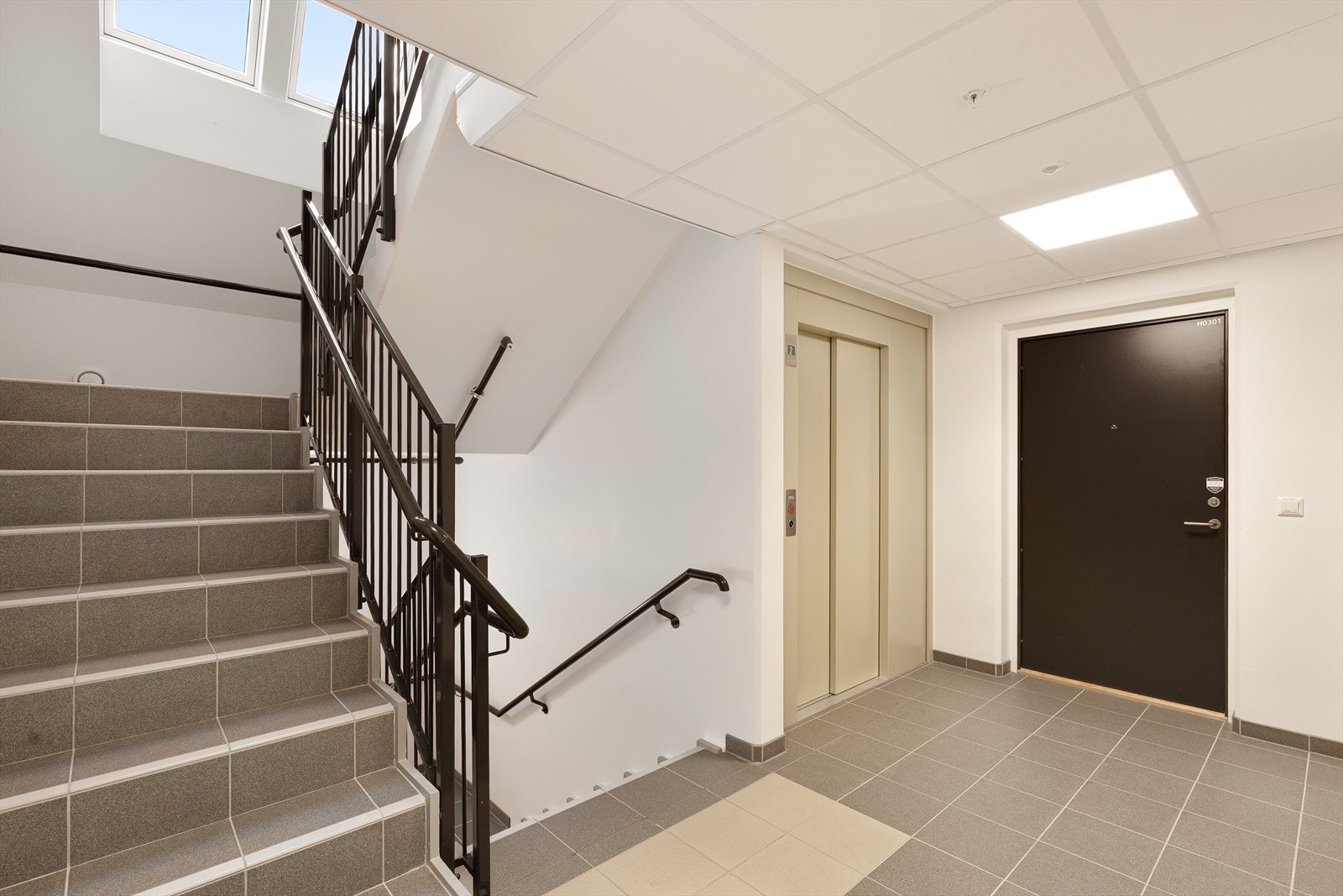 Lys og innbydende trappeoppgang med heisadkomst. Flotte fliser og moderne design gir et godt førsteinntrykk. Galleribilde