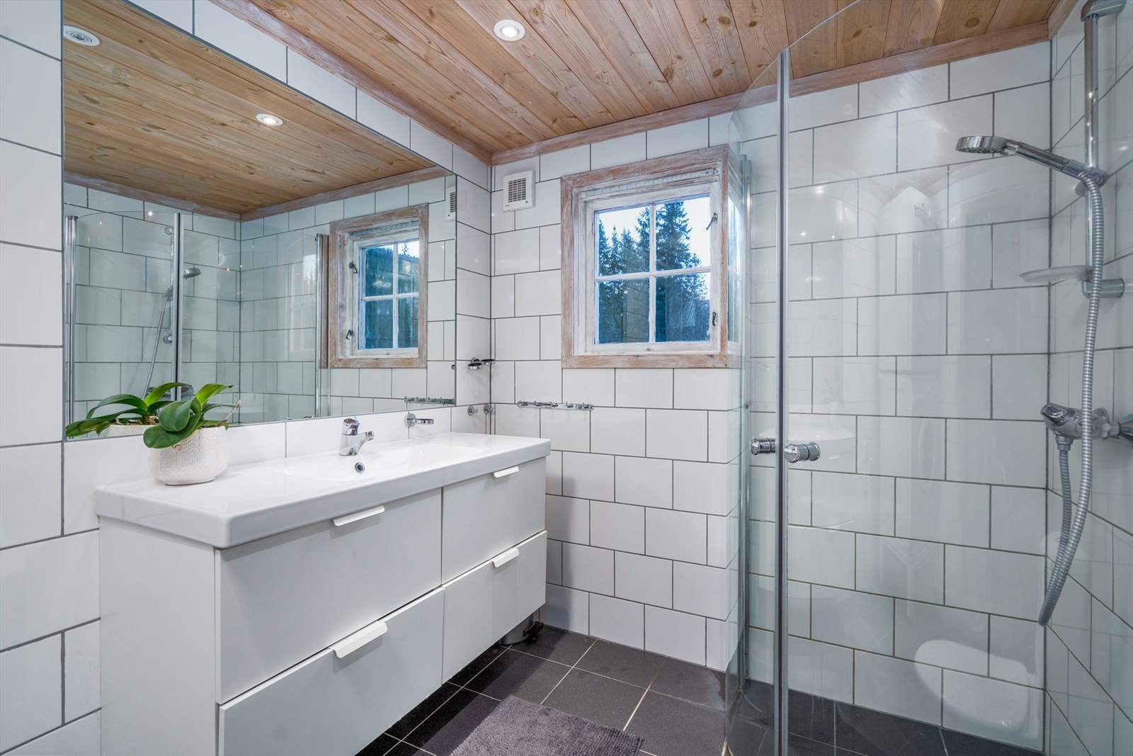 Badet er innredet med servantsseksjon med heldekkende servantplate og innfelt speil, samt servant, wc og dusjhjørne. Galleribilde