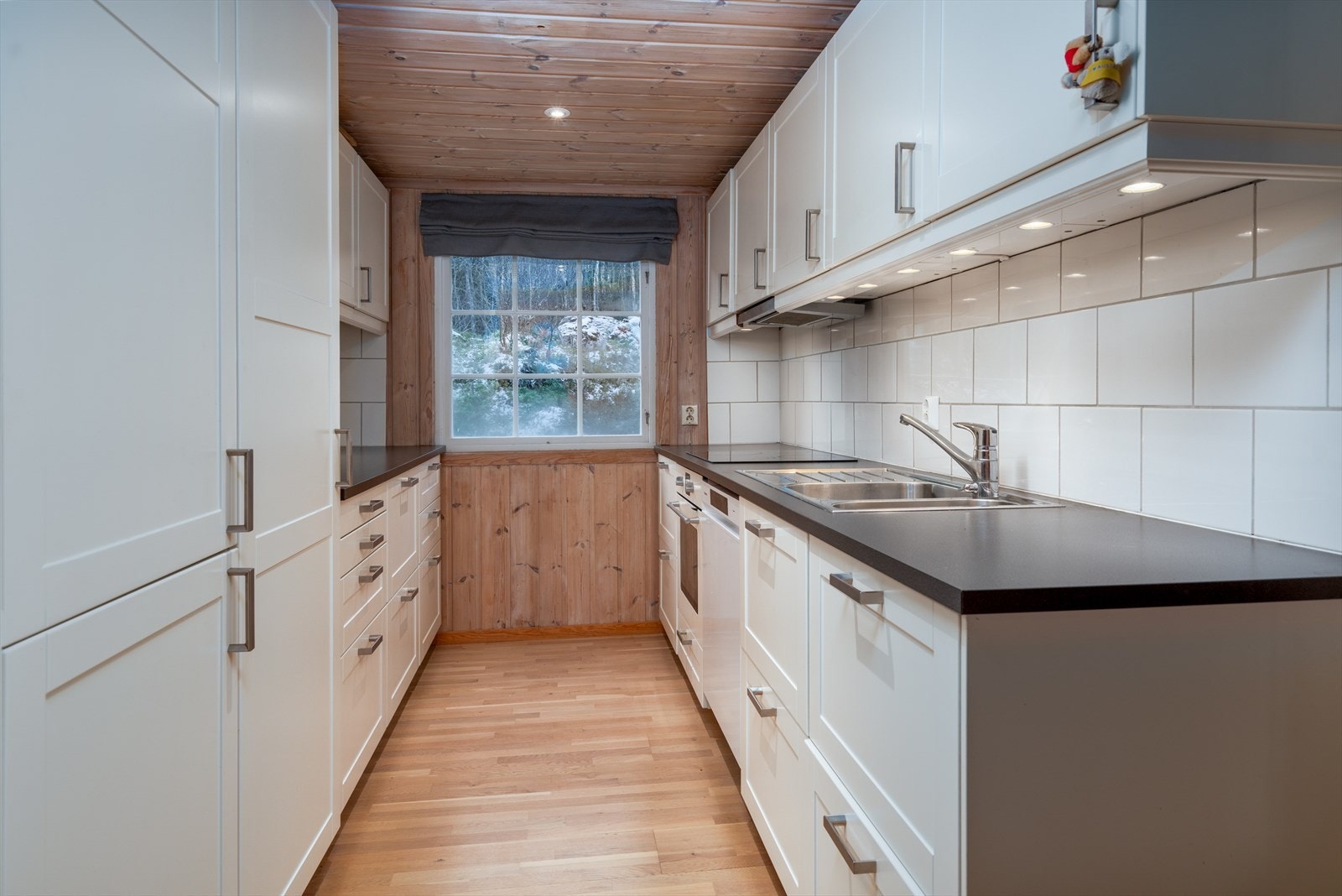 Benkeplaten er i laminat, og det er montert oppvaskkum i rustfritt stål og fliser over benk. Kjøkkenet er utstyrt med integrerte hvitevarer, inkludert komfyrtopp, stekeovn, oppvaskmaskin og kombi kjøl-/fryseskap. Galleribilde