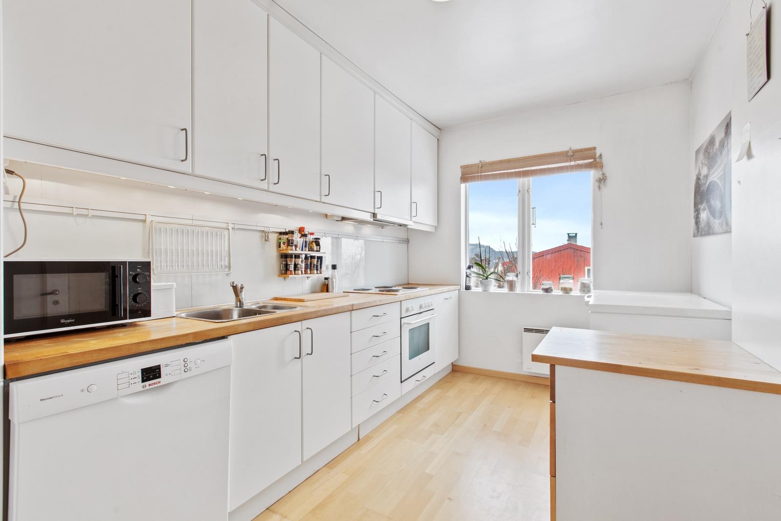 Leiligheten har et romslig kjøkken med mye skap- og benkeplass. Alt av hvitevarer. Galleribilde