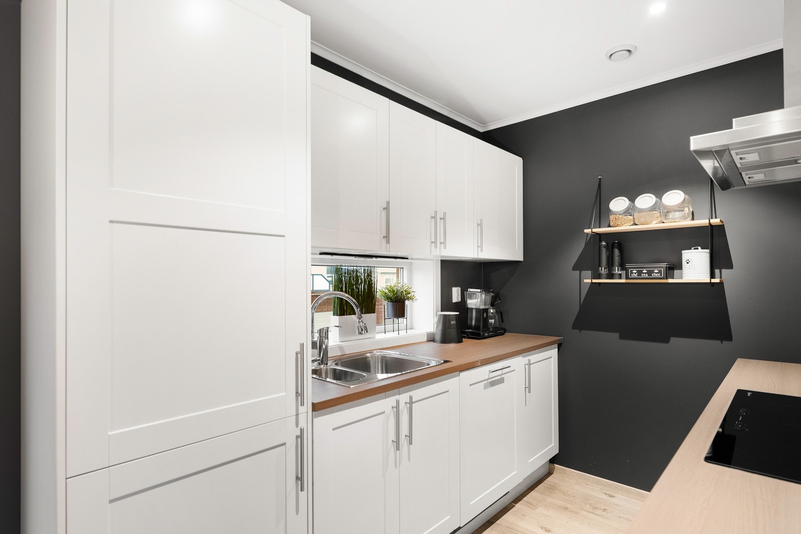 Pen innredning med slette fronter, benkeplate i laminat og integrerte hvitevarer. Galleribilde