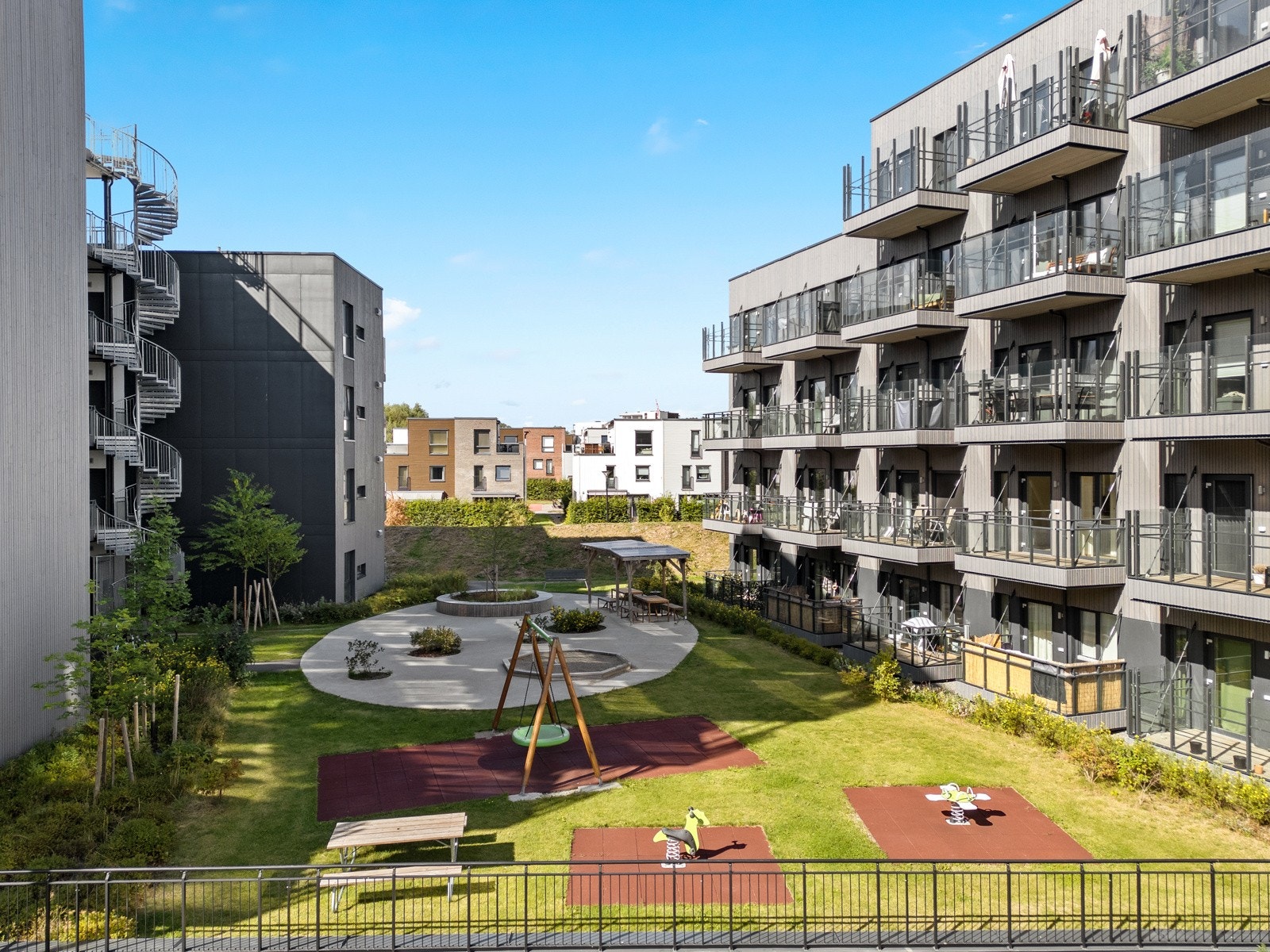 Nærmiljøet er grønt og rolig med parkmessig opparbeidet tomt rundt bygningene, samt fine tun med lekeplasser, markterrasser, sittegrupper og pergola Galleribilde