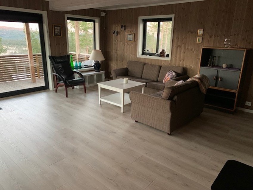 Stuen byr på en sjenerøs gulvplass og er hjertet av hjemmet med sine laminatgulv som gir et varmt og innbydende preg. Galleribilde