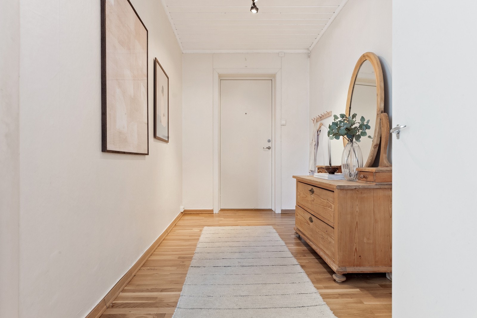 Gangen har plass til enkle garderobeløsninger som smale skoskap, kommoder og freshe knaggrekker på veggen Galleribilde