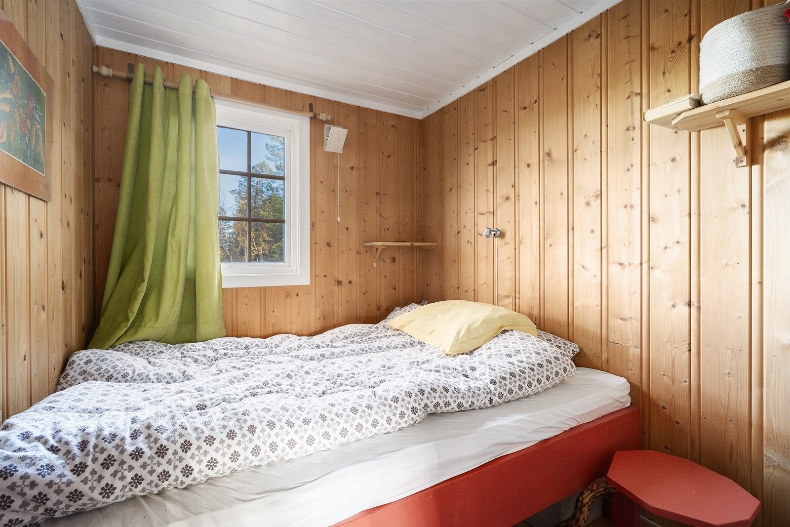 Et av hyttas to soverom, lyst og trivelig med panel på vegger. Galleribilde