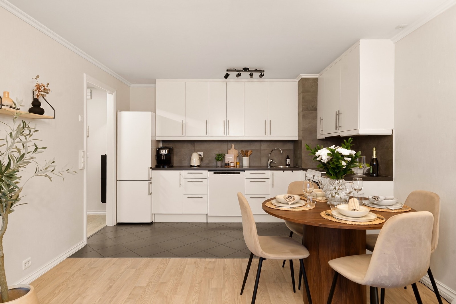 Et lyst og praktisk kjøkken med frittstående hvitevarer. Galleribilde