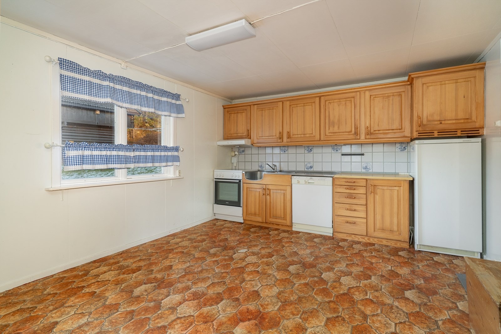 Kjøkkenet har innredning med profilerte fronter og benkeplate av laminat. Det er opplegg for oppvaskmaskin og ventilator med avtrekk ut. Galleribilde